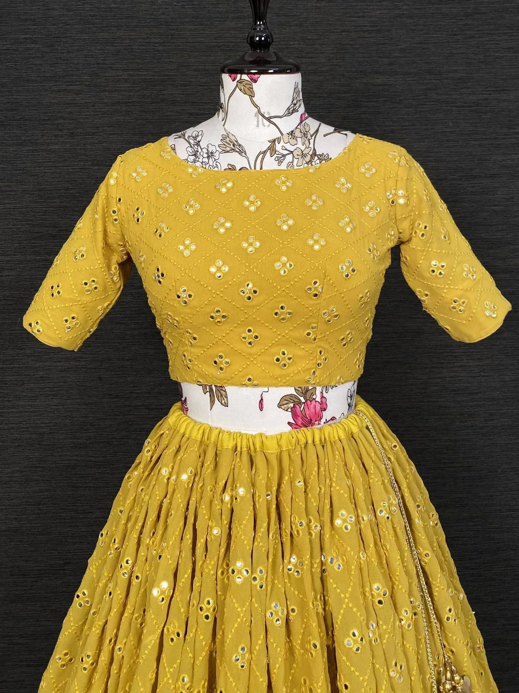 Yellow mirror work lehenga choli with floral embroidery, perfect for Indian ethnic wear events