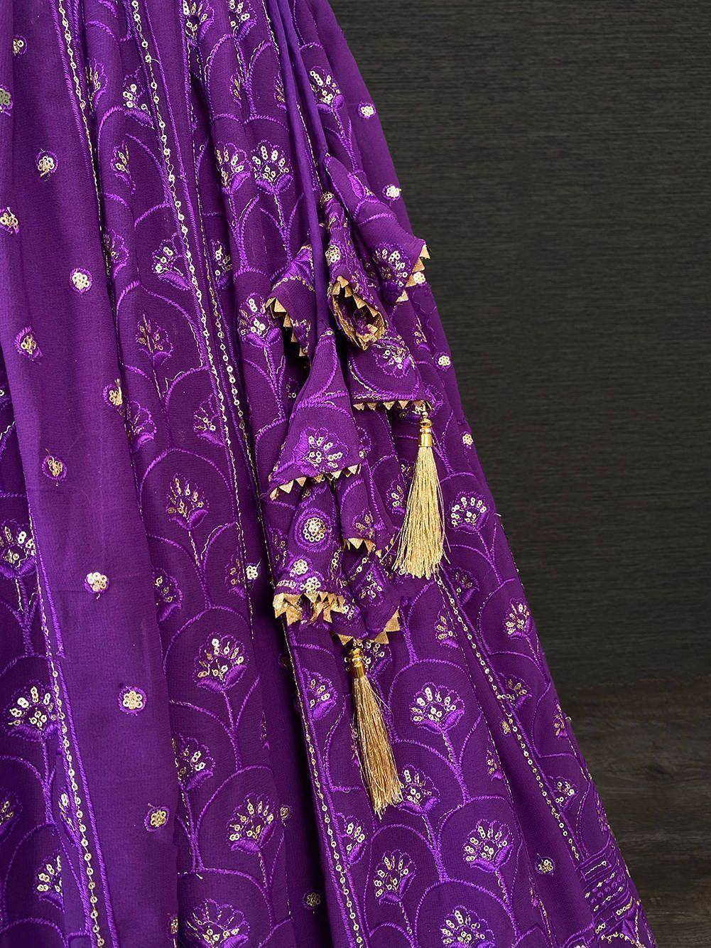 Purple ethnic lehenga with gold floral embroidery and tassels, ideal for Indian weddings and festivals