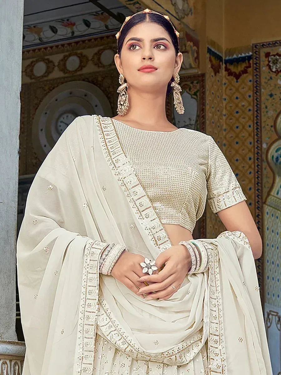 Elegant ivory ethnic saree with gold embroidery, perfect for Indian weddings and festive occasions.