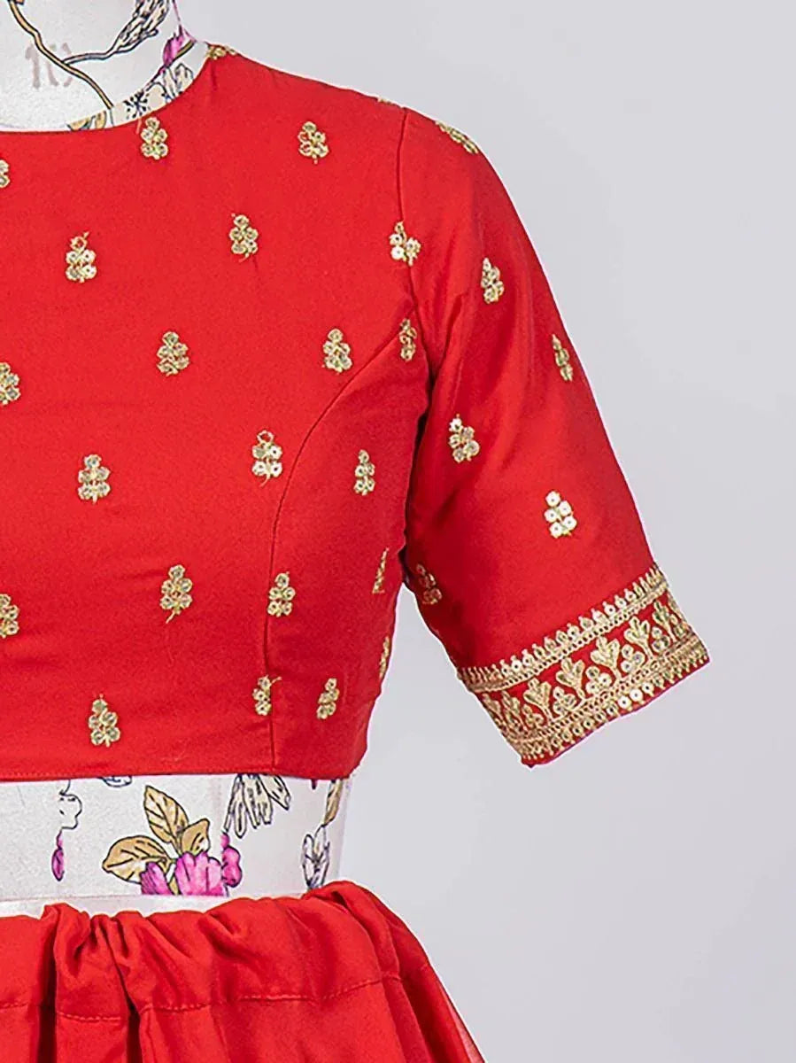 Red ethnic blouse with gold floral embroidery and detailed sleeve border, paired with printed skirt