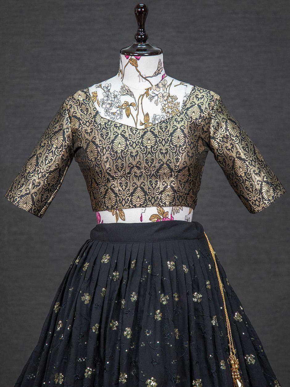 Black and gold embroidered lehenga choli with floral motifs and pleated skirt, perfect for Indian ethnic wear