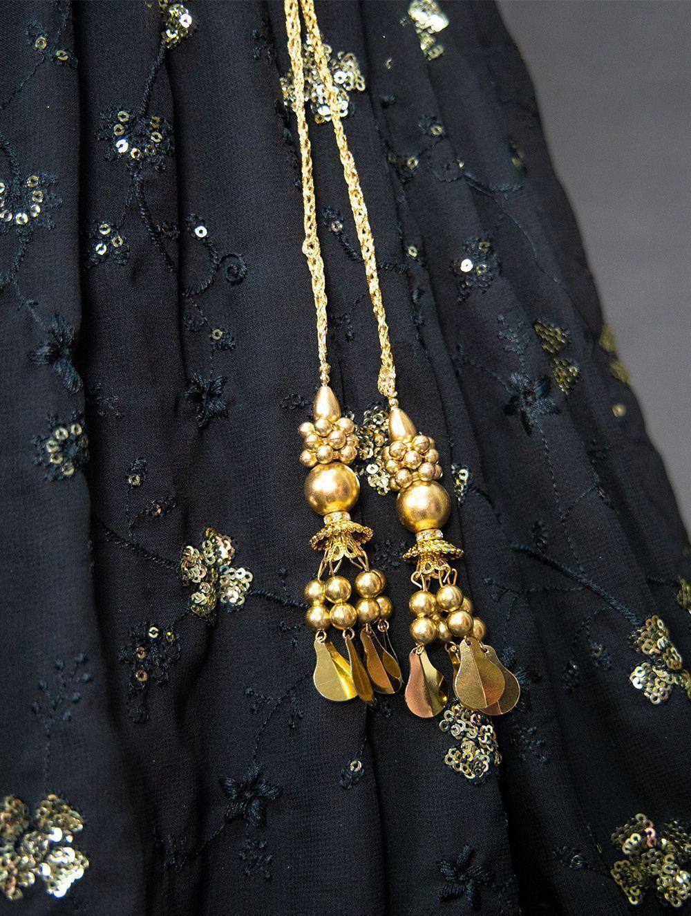 Black embroidered ethnic gown with gold tassel necklace, perfect for Indian festive wear