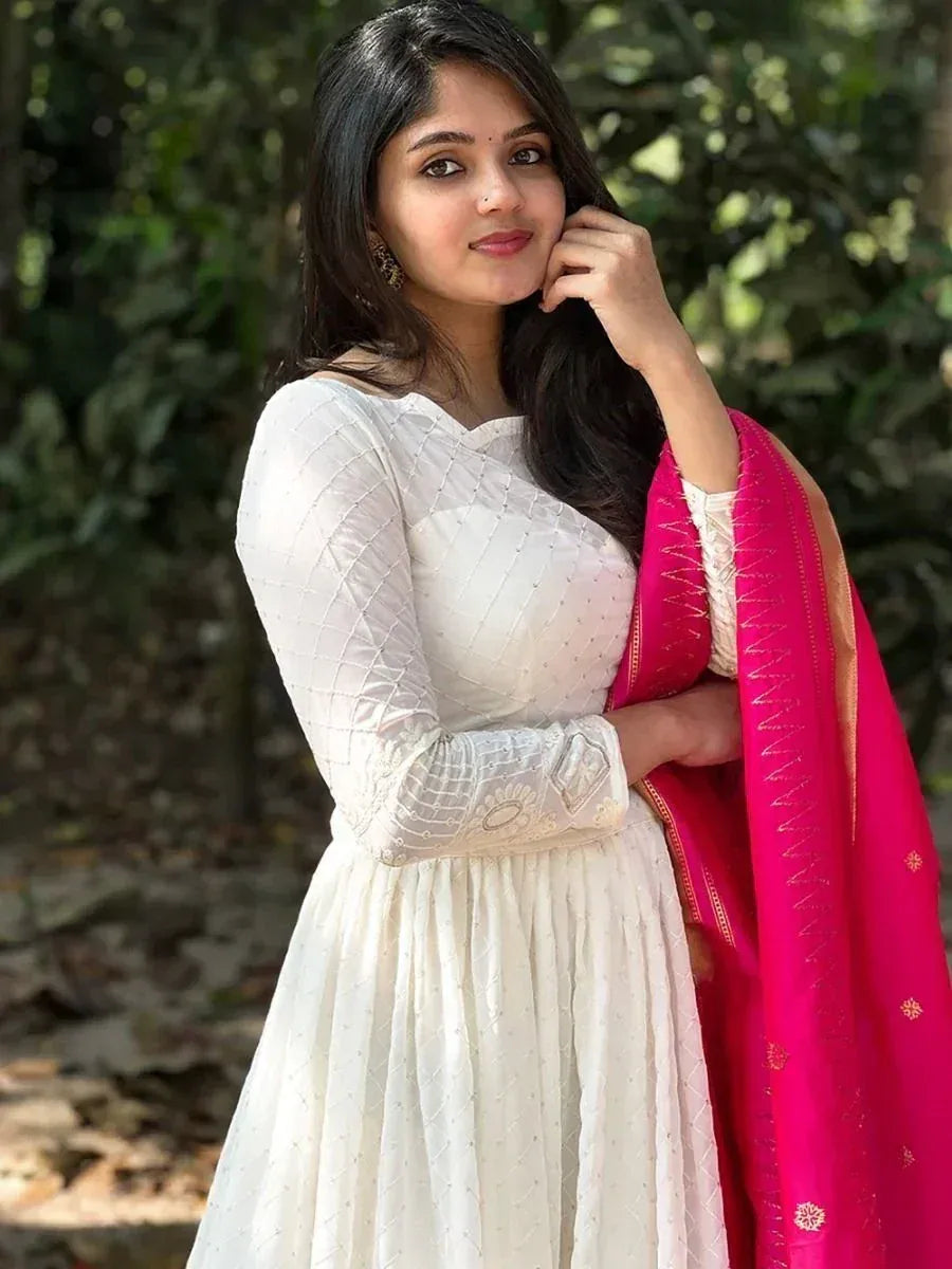White embroidered ethnic gown with pink dupatta, perfect for Indian occasions and festive wear.