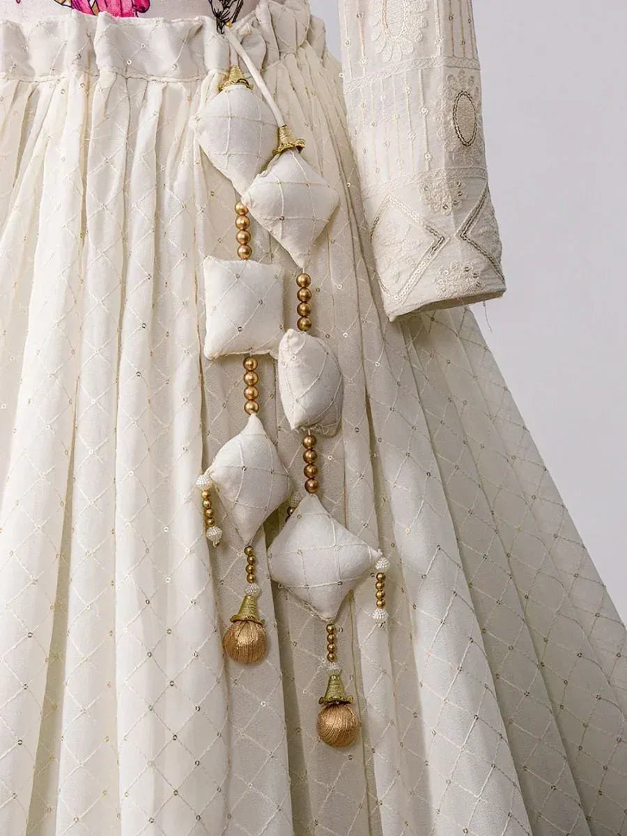 White embroidered lehenga choli with quilted tassels and gold bead detailing, ethnic Indian wear
