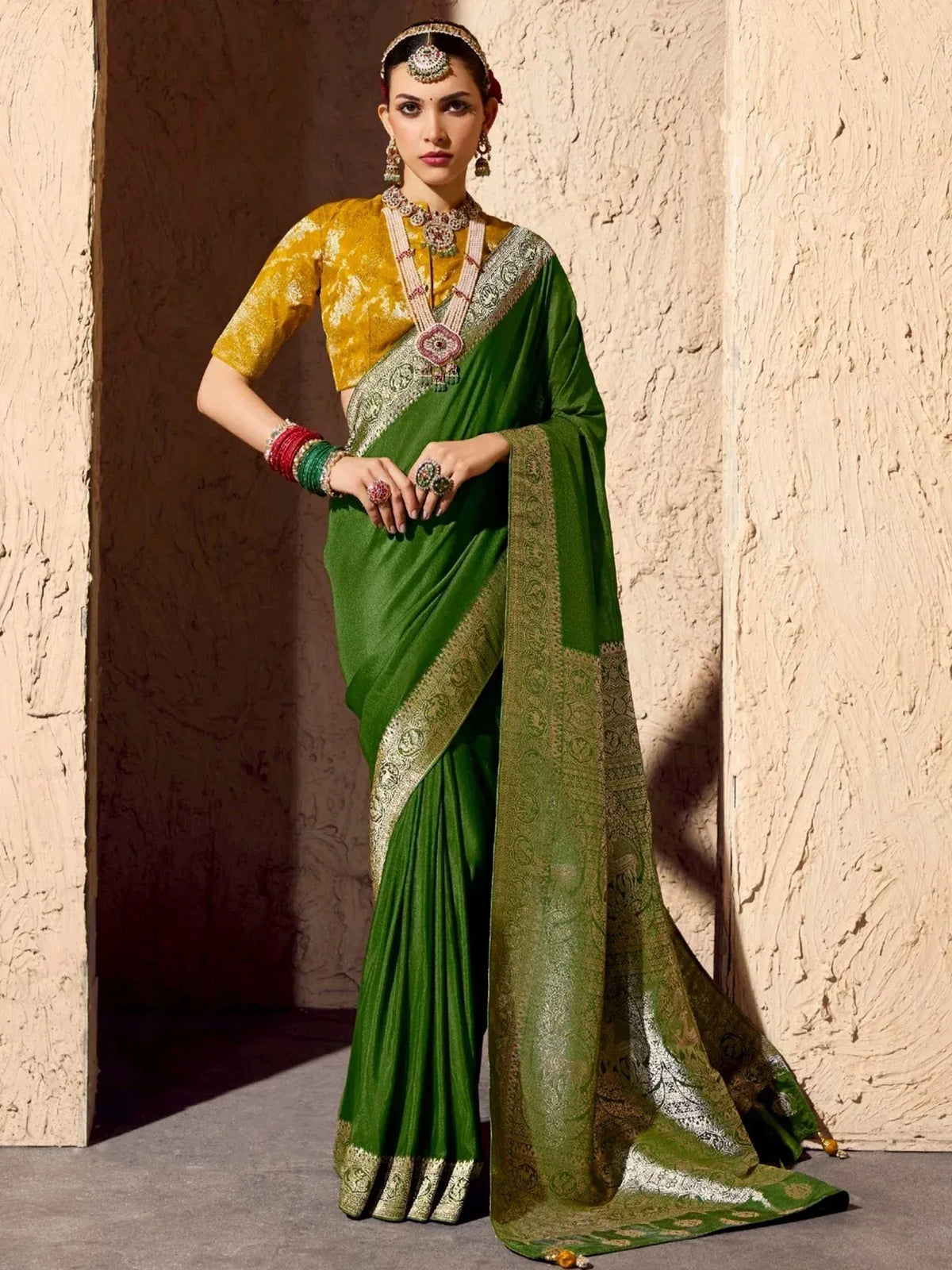 Elegant green saree with gold border, paired with yellow blouse and traditional jewelry for Indian ethnic wear.
