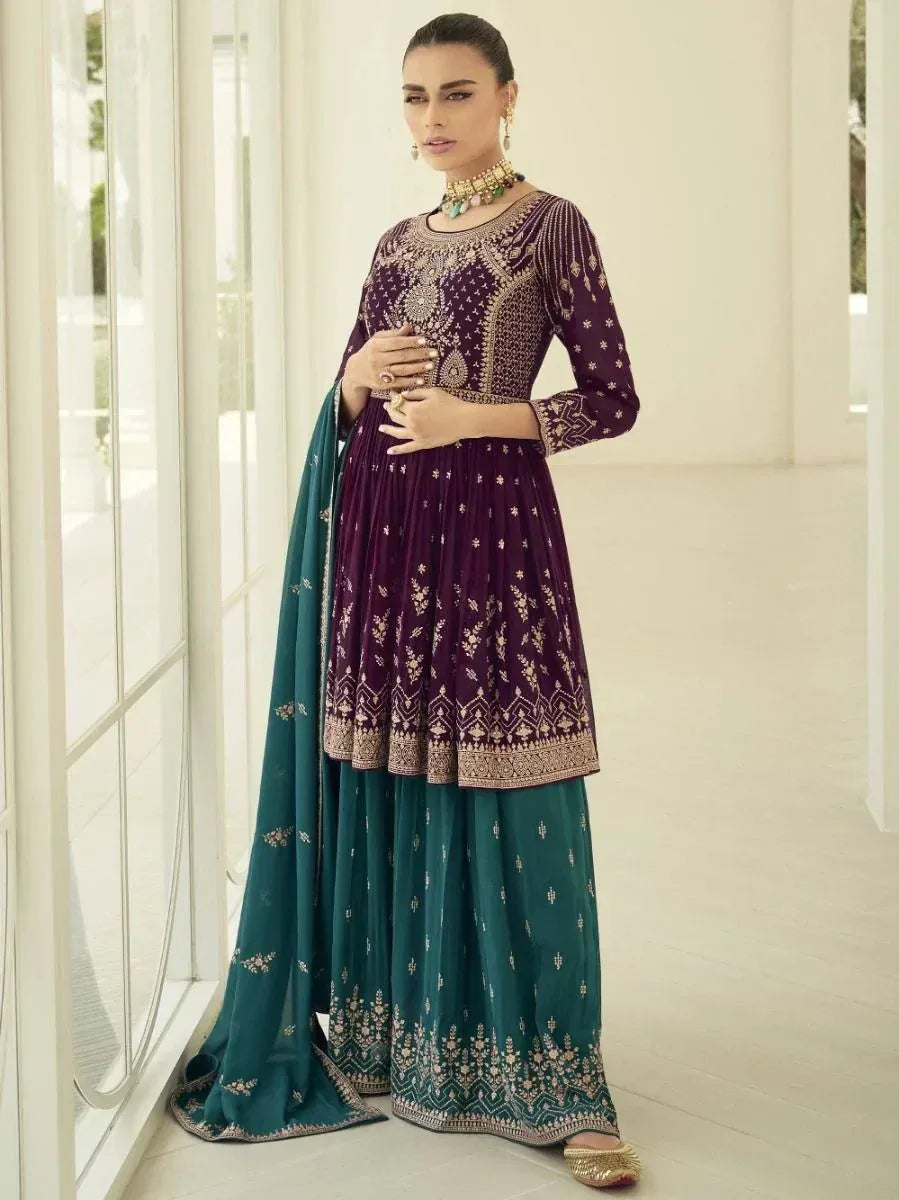 Woman wearing a designer purple and teal embroidered salwar kameez with dupatta
