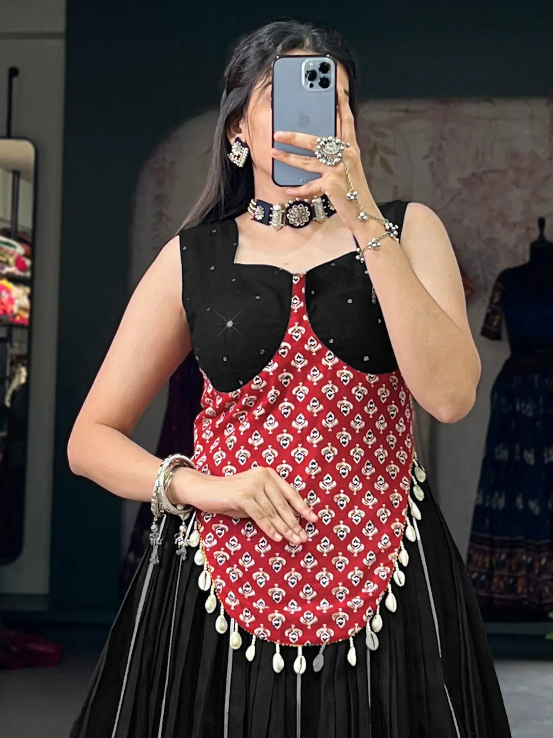 Black and red ethnic gown with mirror work and shell embellishments, styled with traditional jewelry