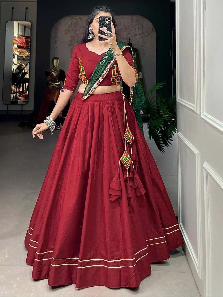 Maroon lehenga choli with green dupatta, mirror work, and ruffle details for Indian ethnic wear