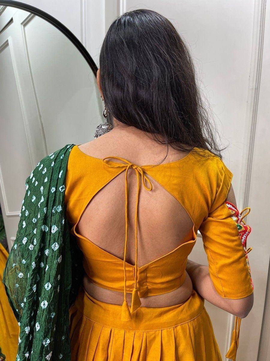 Yellow backless lehenga choli with tie-up detail and green dupatta, ethnic Indian wear