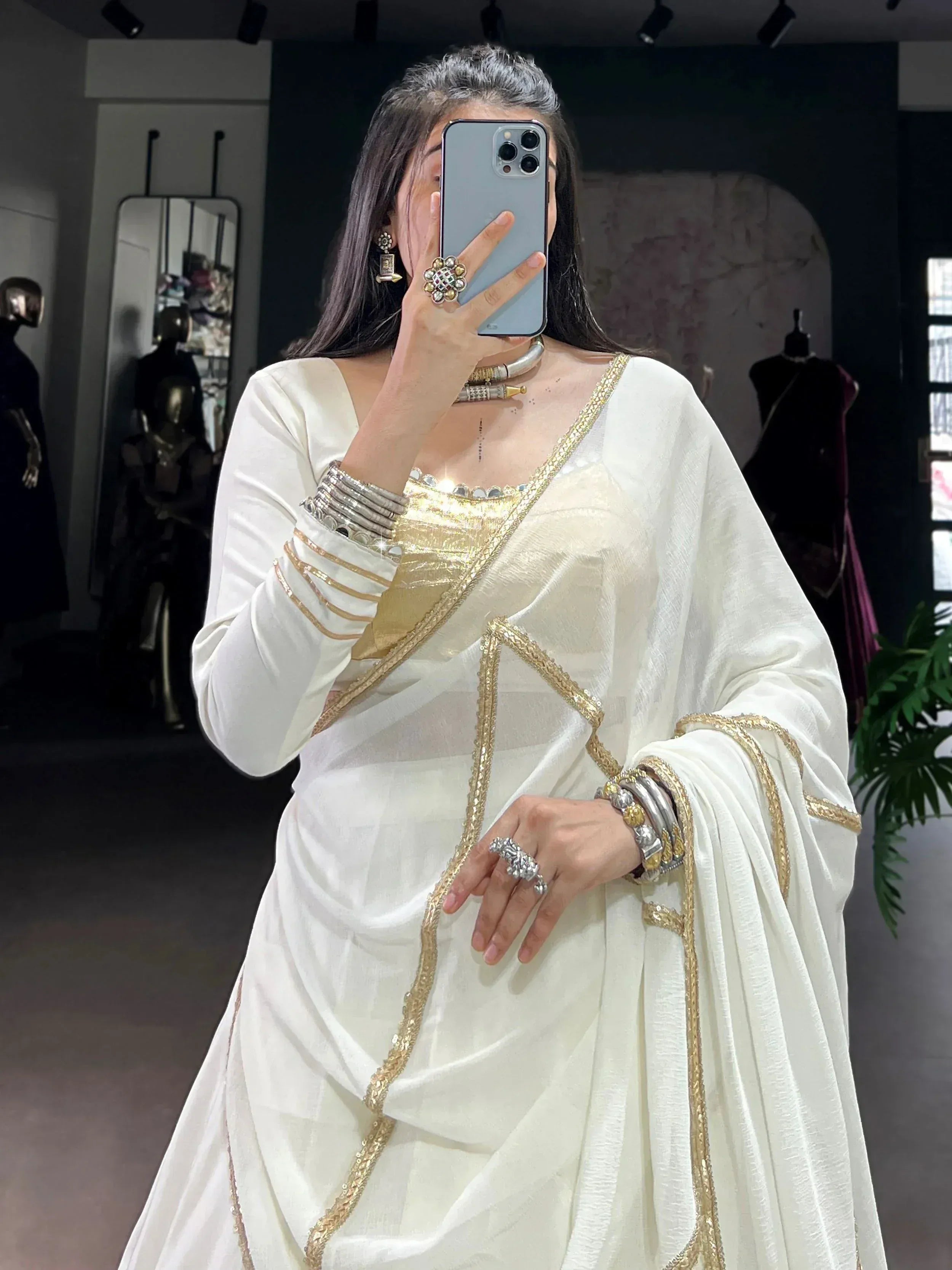 Elegant white saree with gold embroidery, paired with traditional Indian jewelry for festive occasions