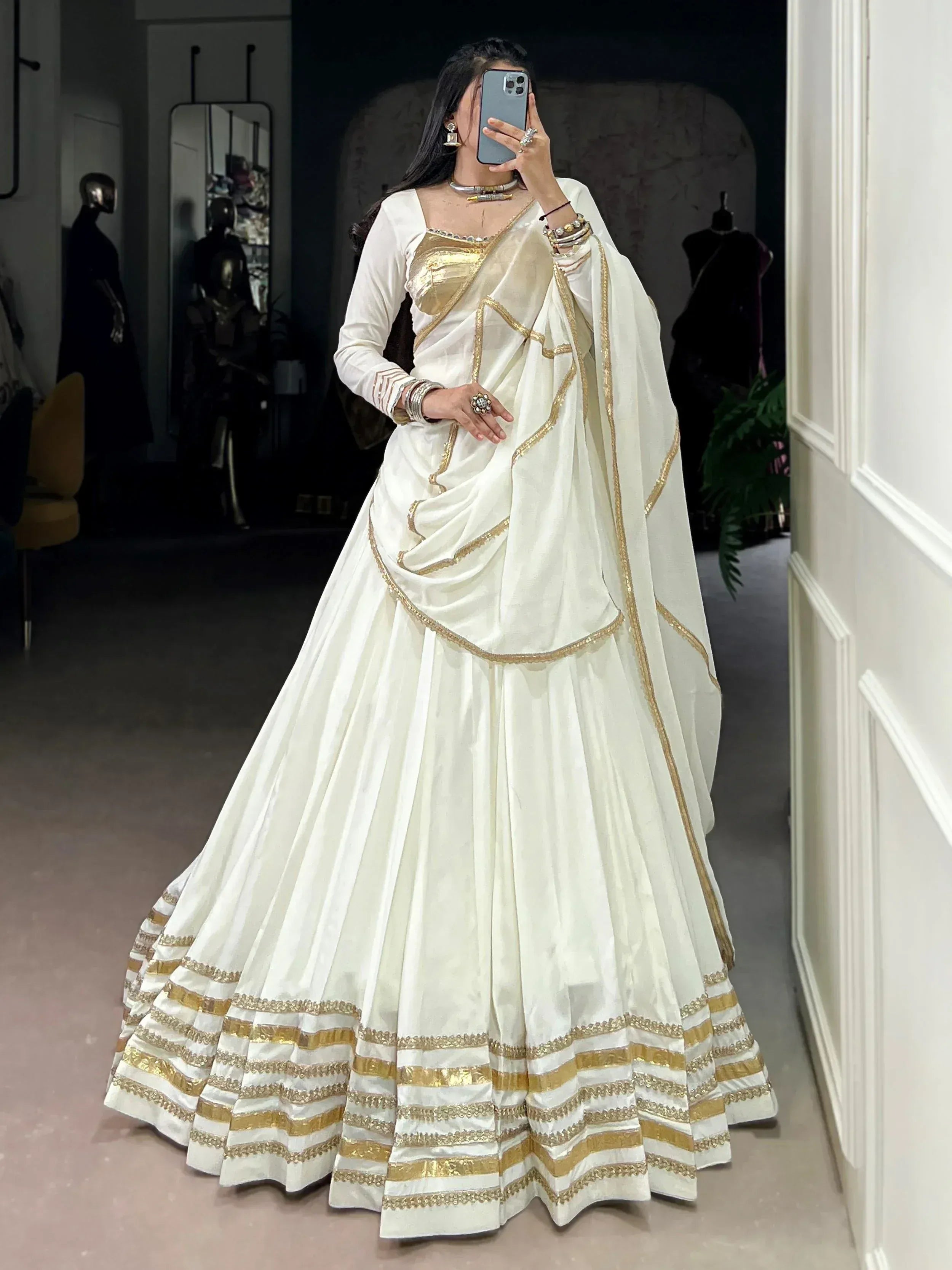 White and gold designer lehenga choli with intricate embroidery, perfect for Indian ethnic wear occasions.