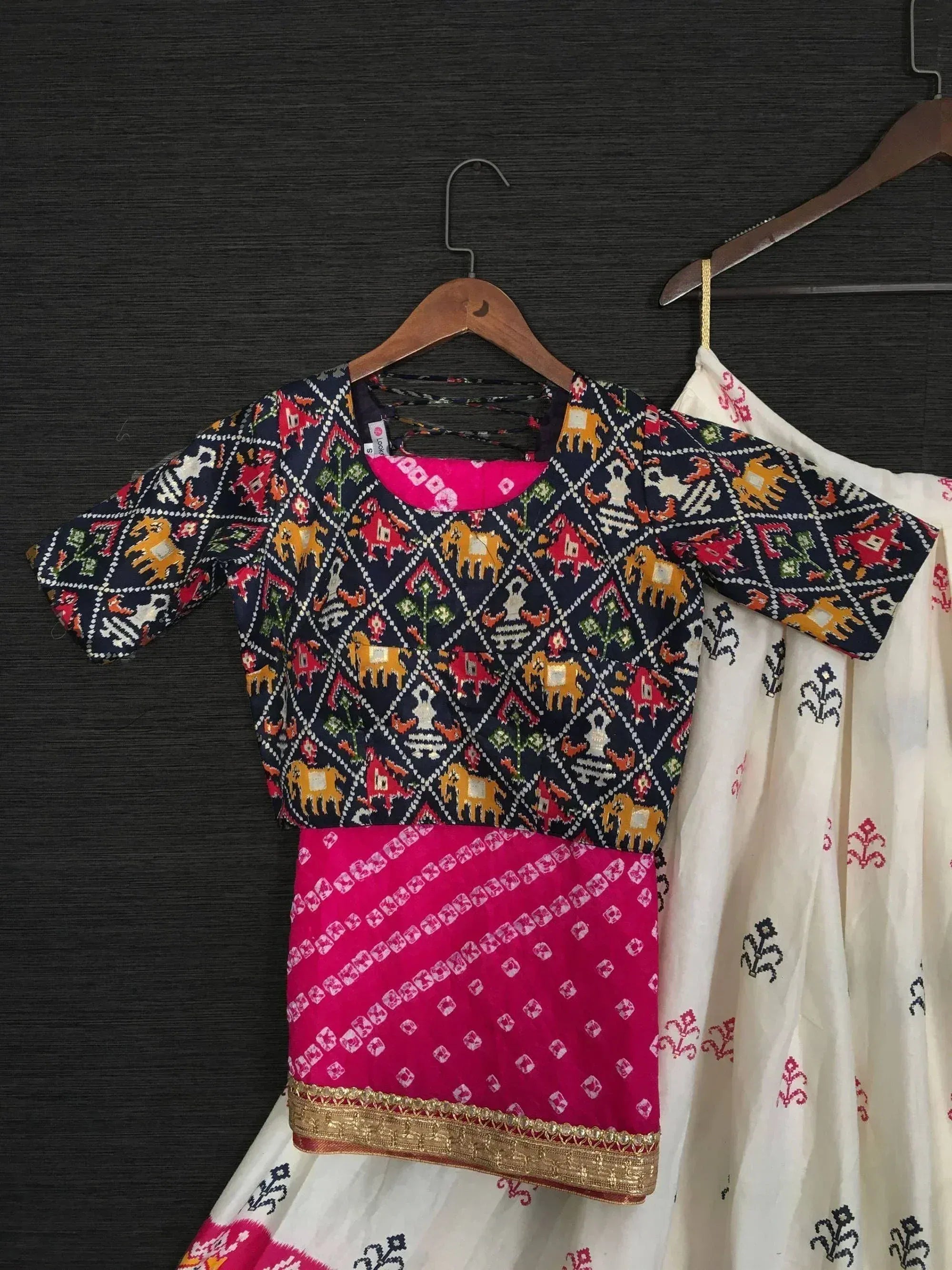 Ethnic printed blouse with elephant motifs and pink border, paired with white skirt