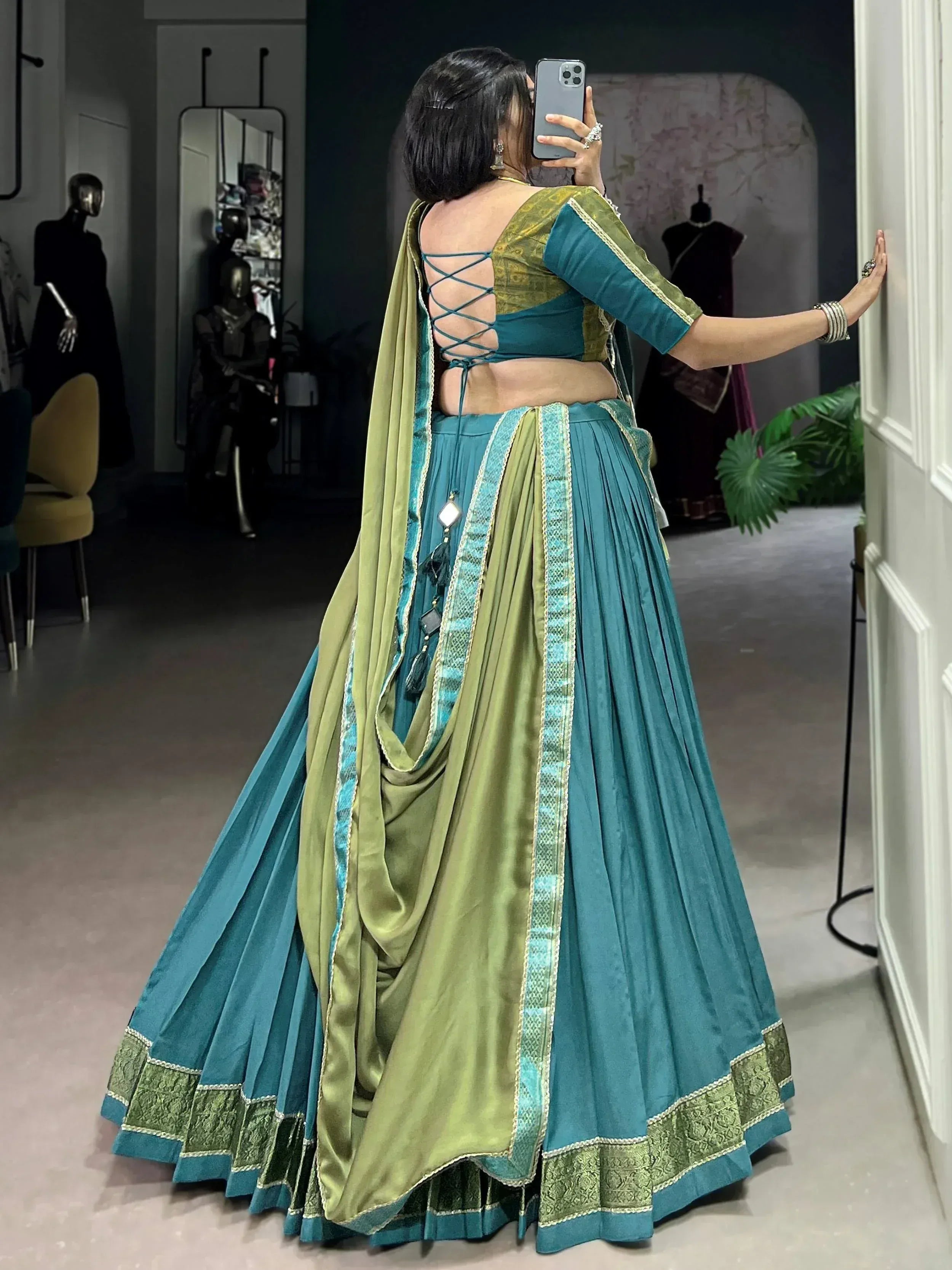 Teal and olive green designer lehenga choli with crisscross back, perfect for Indian ethnic wear events.