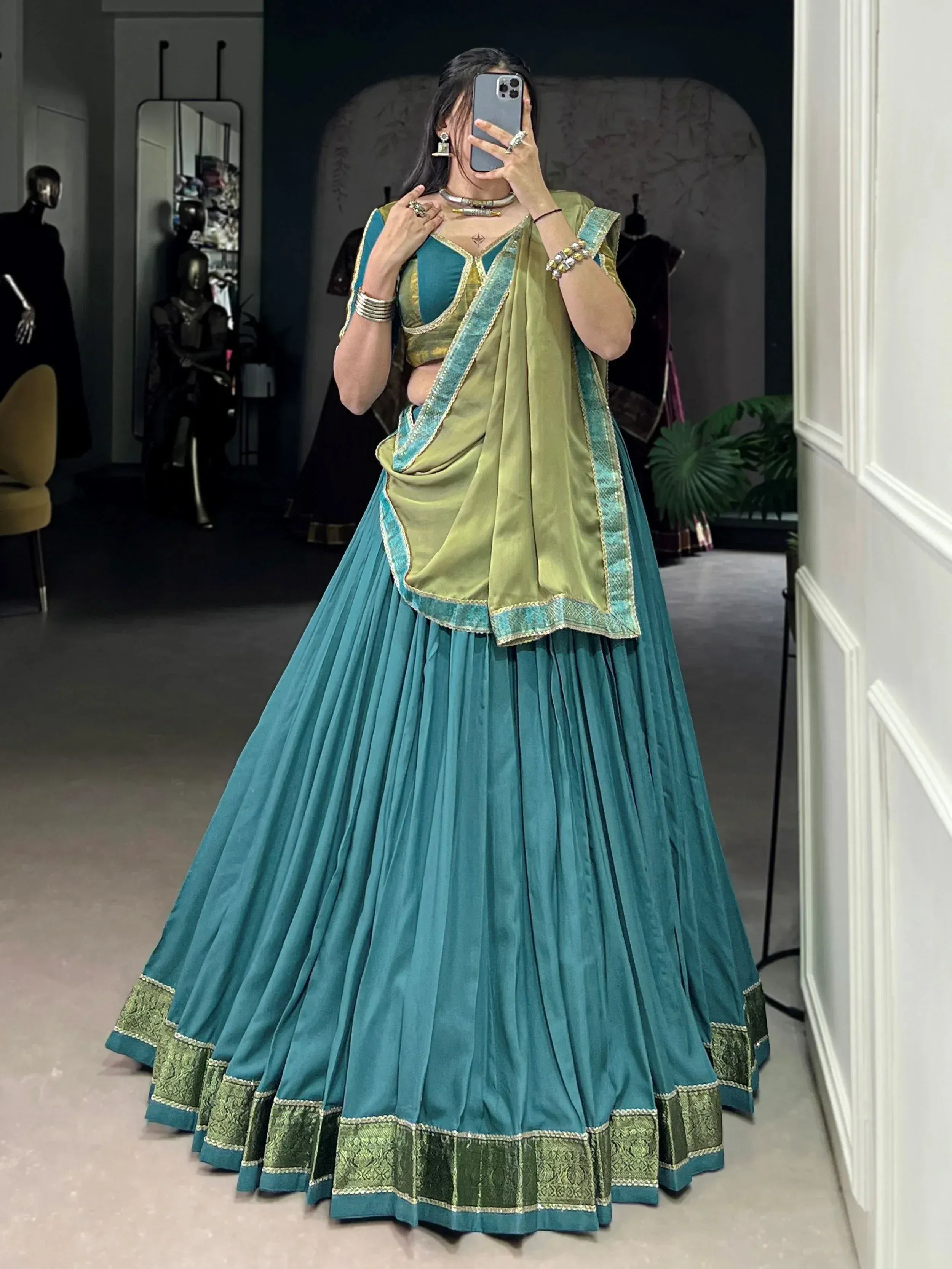Teal and olive green designer lehenga choli with embroidered border, perfect for Indian ethnic wear occasions.
