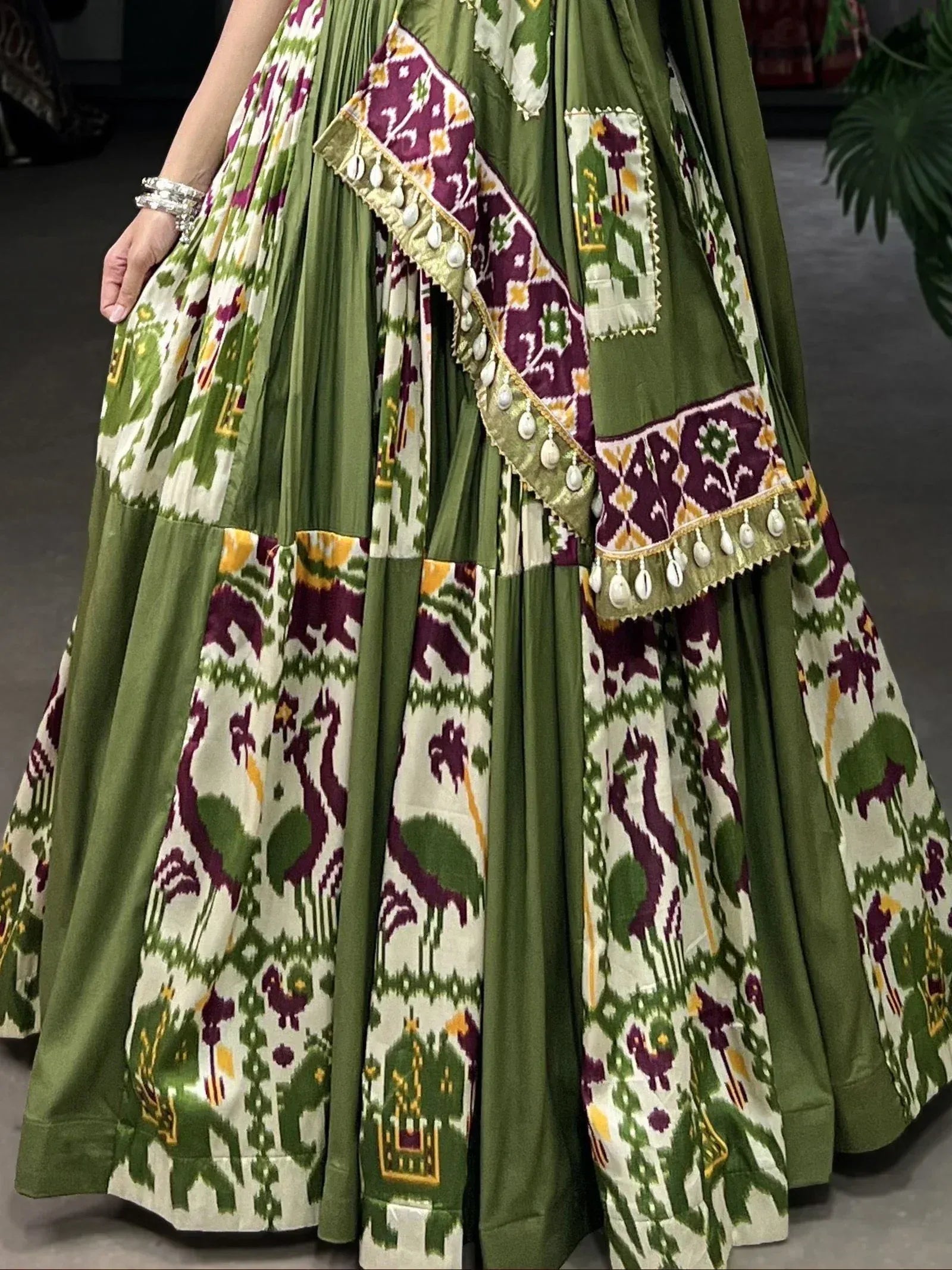 Green and maroon printed ethnic lehenga with patchwork and tassels, perfect for Indian celebrations.