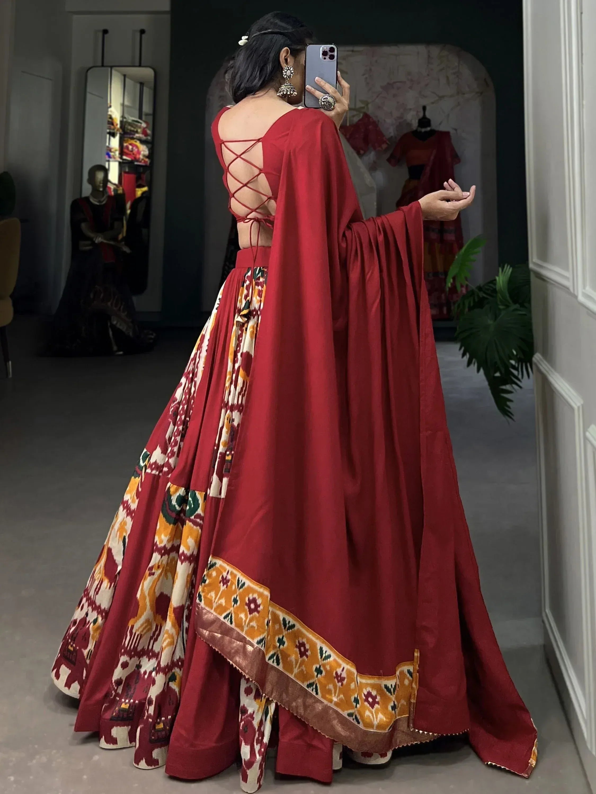 Red ethnic lehenga choli with crisscross back and ikat print skirt, perfect for Indian weddings or festivals