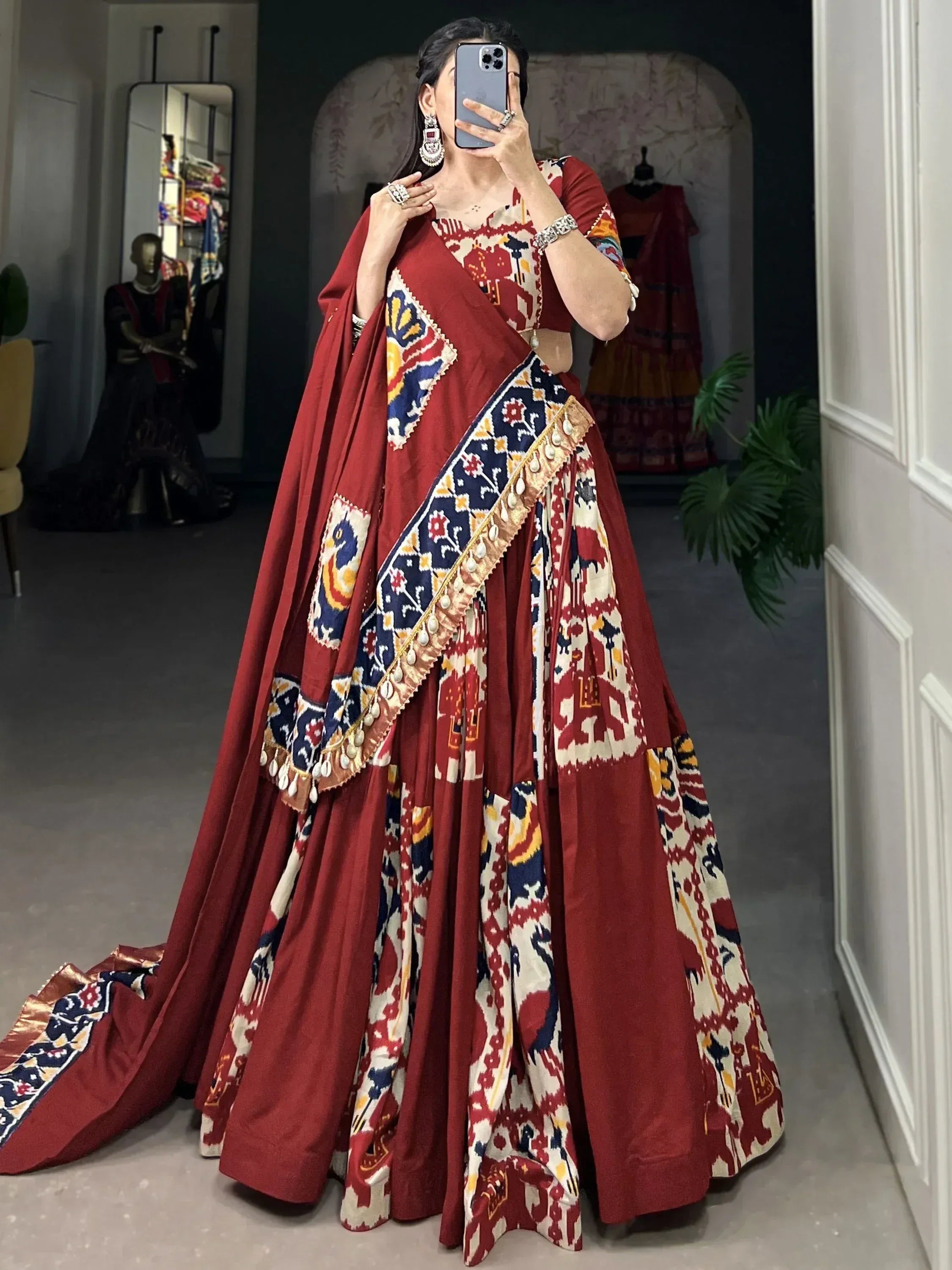 Woman in maroon printed lehenga choli with ethnic motifs and dupatta, perfect for Indian weddings or festivals.