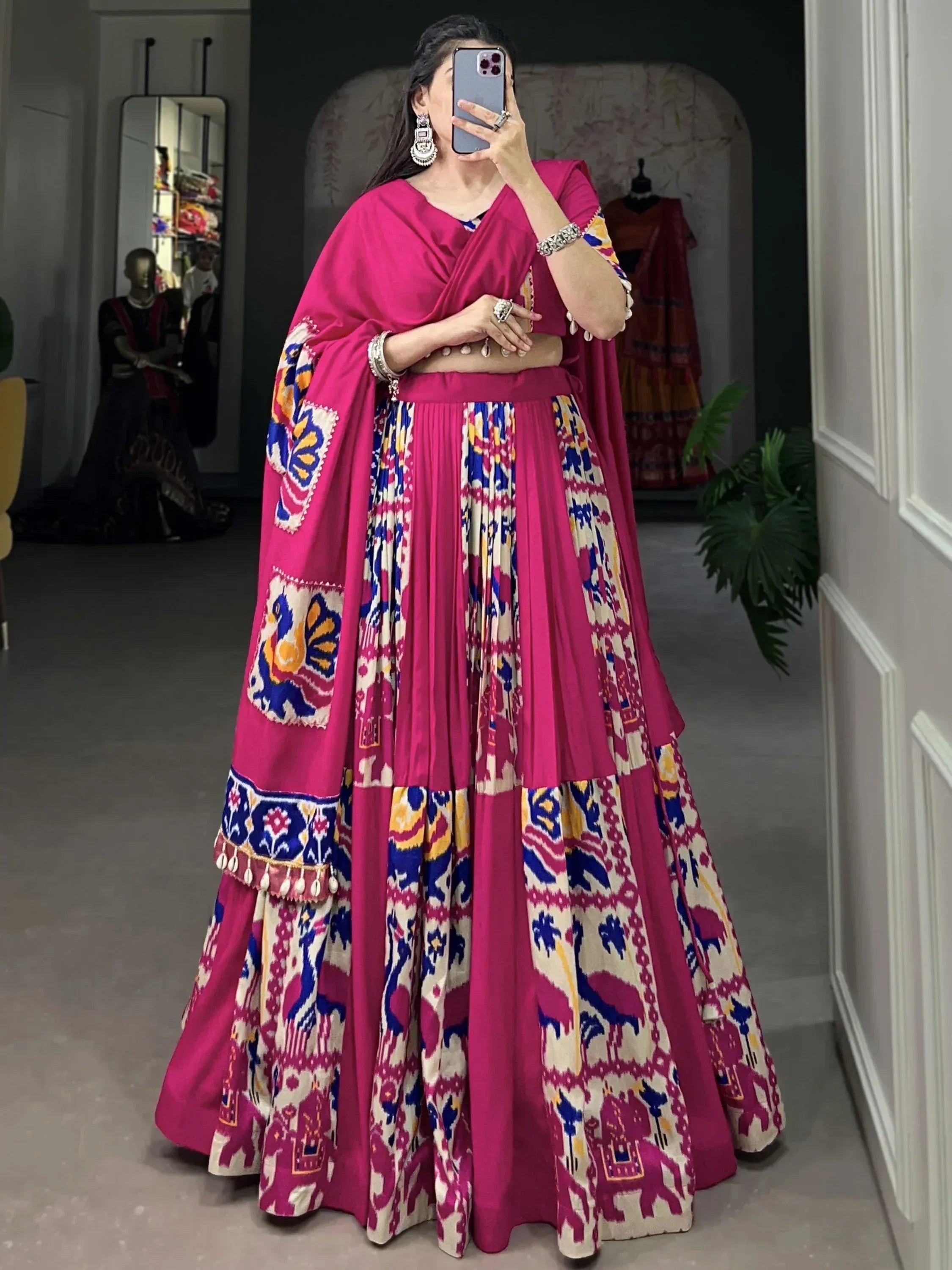 Vibrant pink lehenga choli with colorful ikat print and embroidery, perfect for Indian ethnic wear occasions.