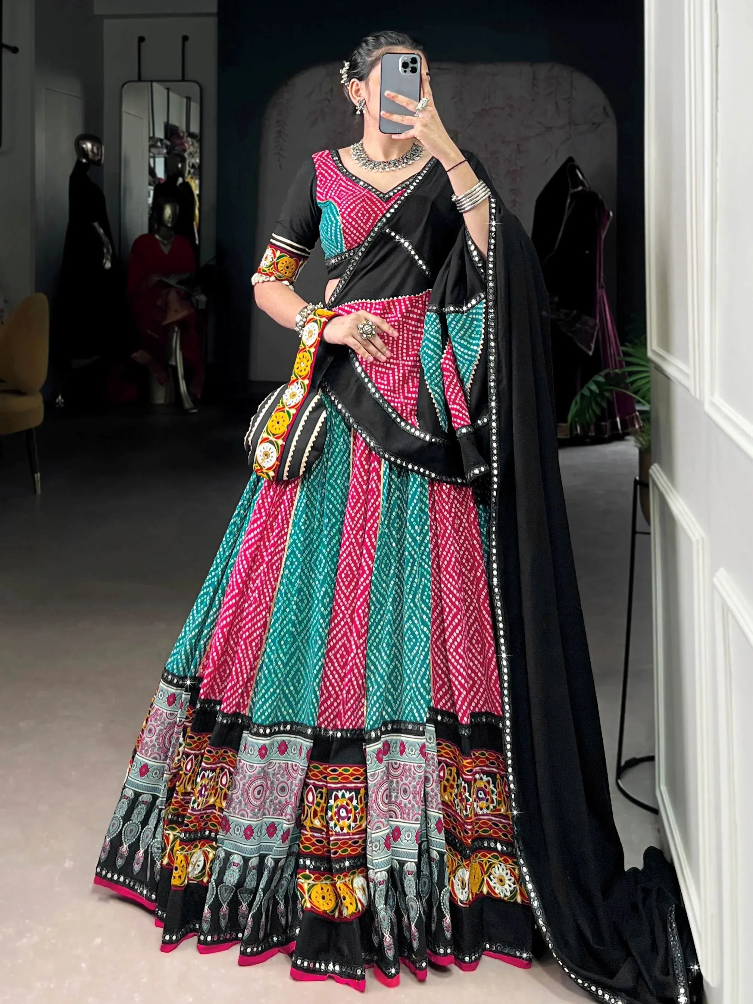 Black, pink, and teal embroidered lehenga choli with mirror work, perfect for Indian ethnic wear occasions.