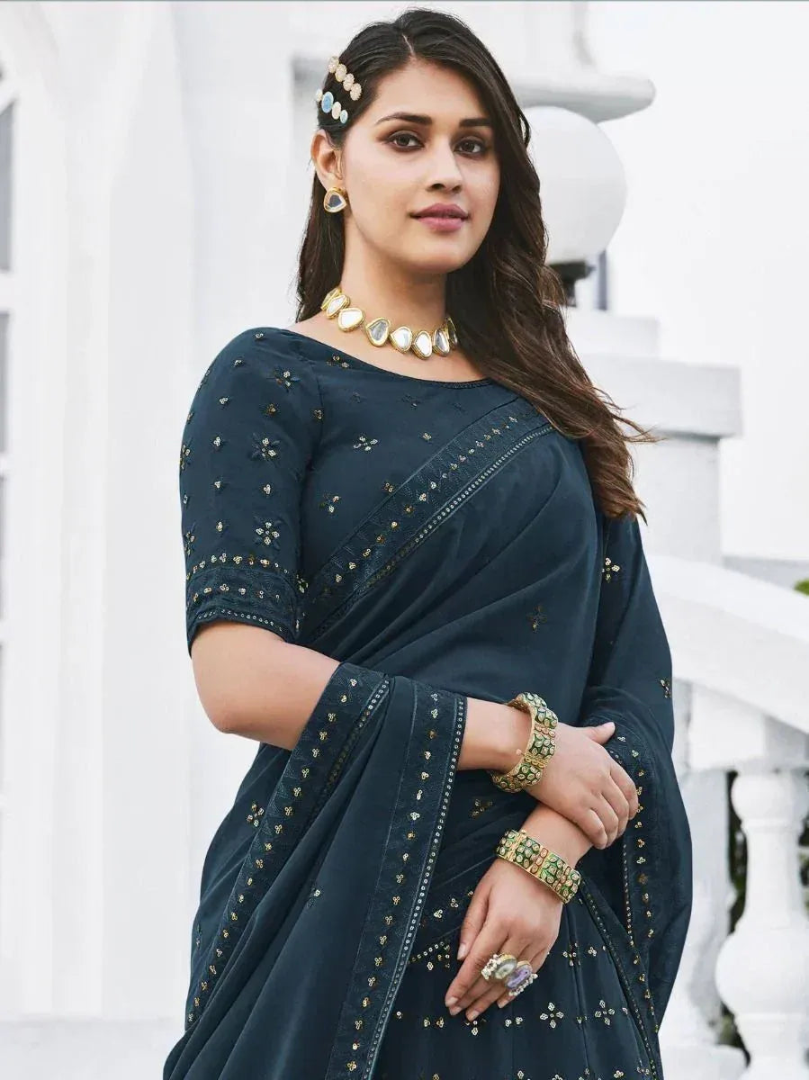 Elegant dark blue embroidered saree with gold detailing, styled with traditional jewelry for Indian ethnic wear.