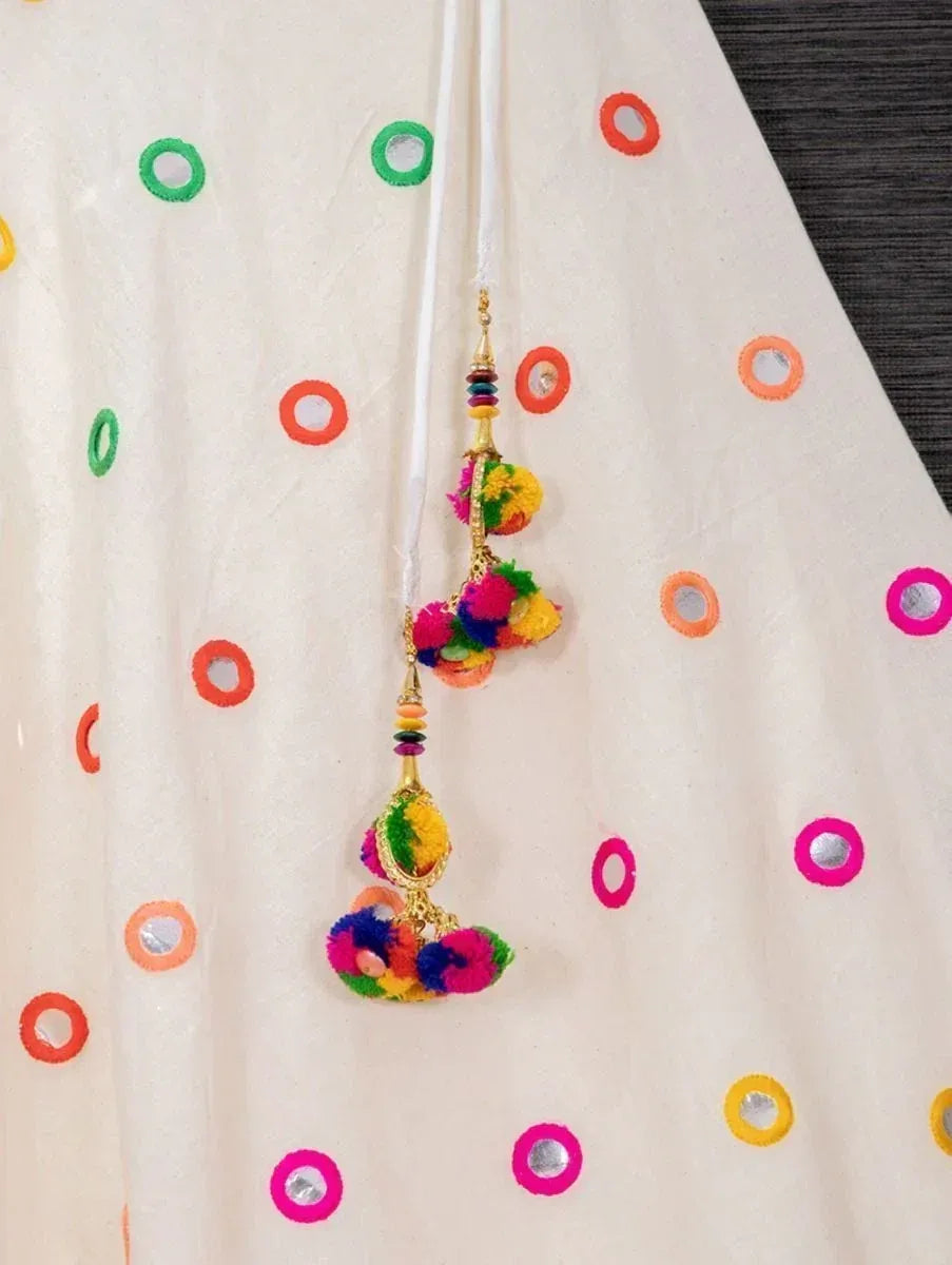 Colorful pom-pom tassels on cream ethnic dress with mirror work circles