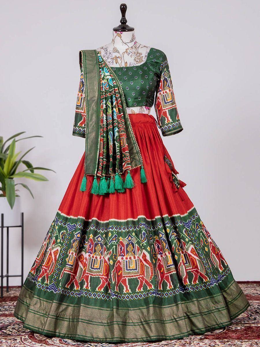 Vibrant red and green ethnic lehenga choli with elephant print, tassels, and dupatta for festive occasions