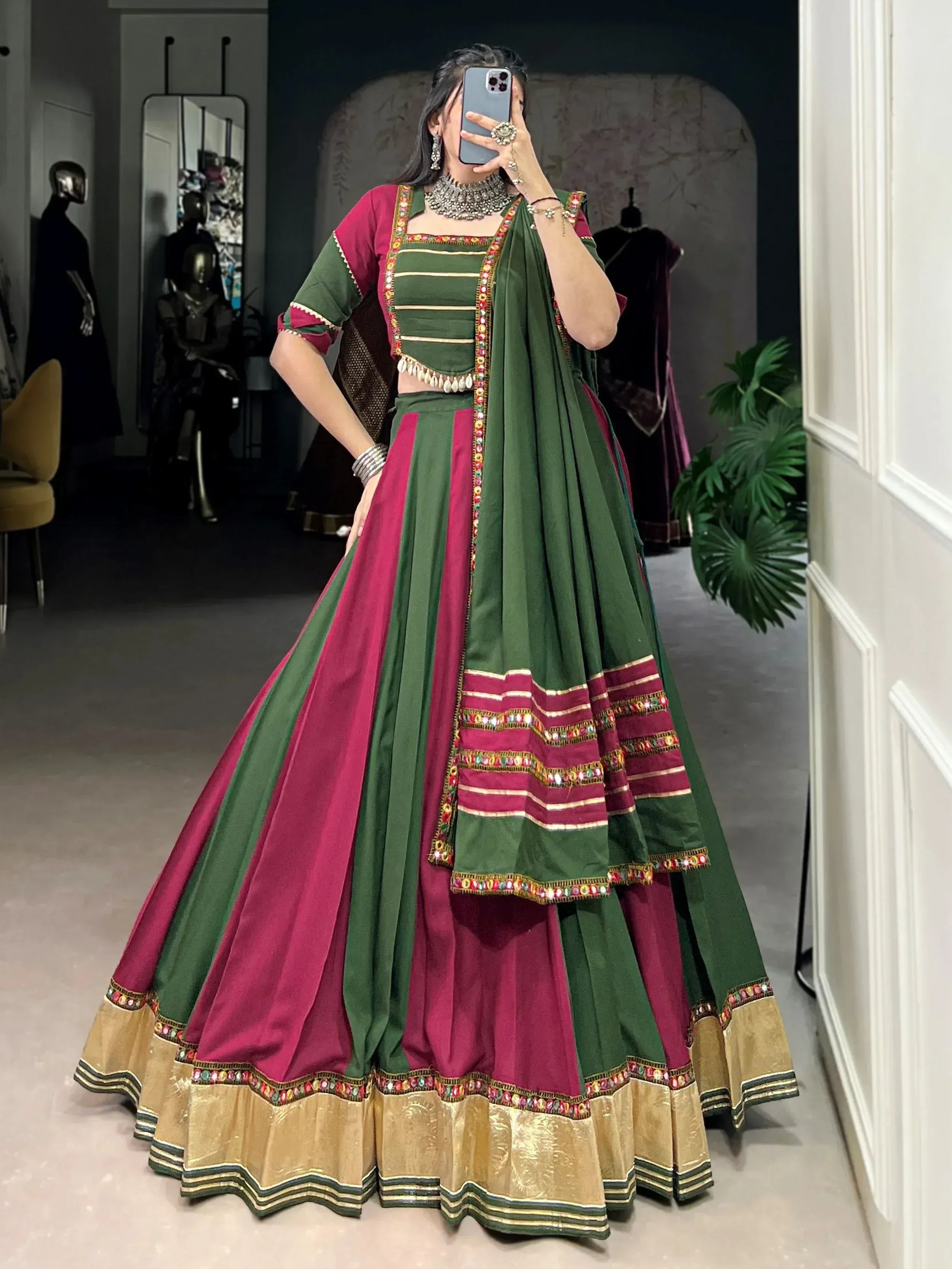 Green and maroon designer lehenga choli with mirror work and gold border, perfect for Indian ethnic occasions.