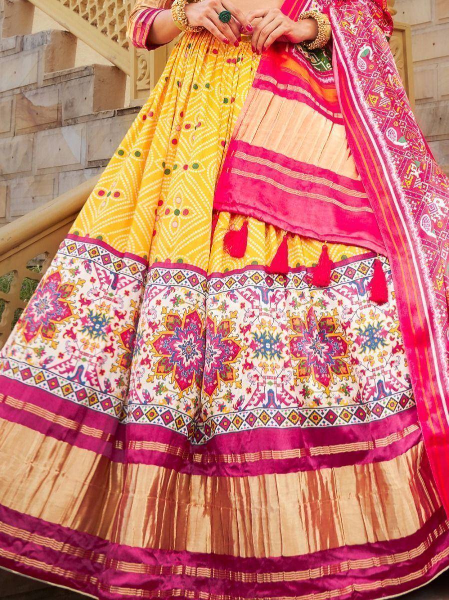 Vibrant yellow and pink printed lehenga choli with intricate floral patterns and tassels, perfect for festive occasions.