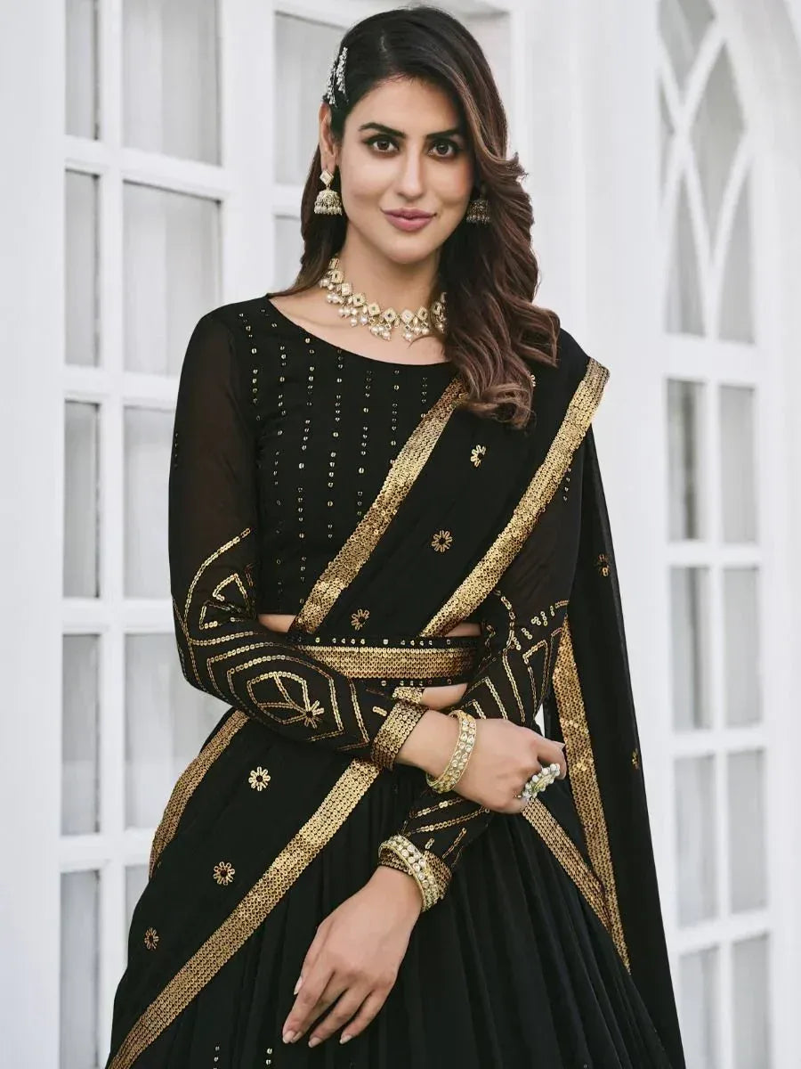 Black and gold embroidered lehenga choli with matching jewelry, perfect for Indian ethnic occasions