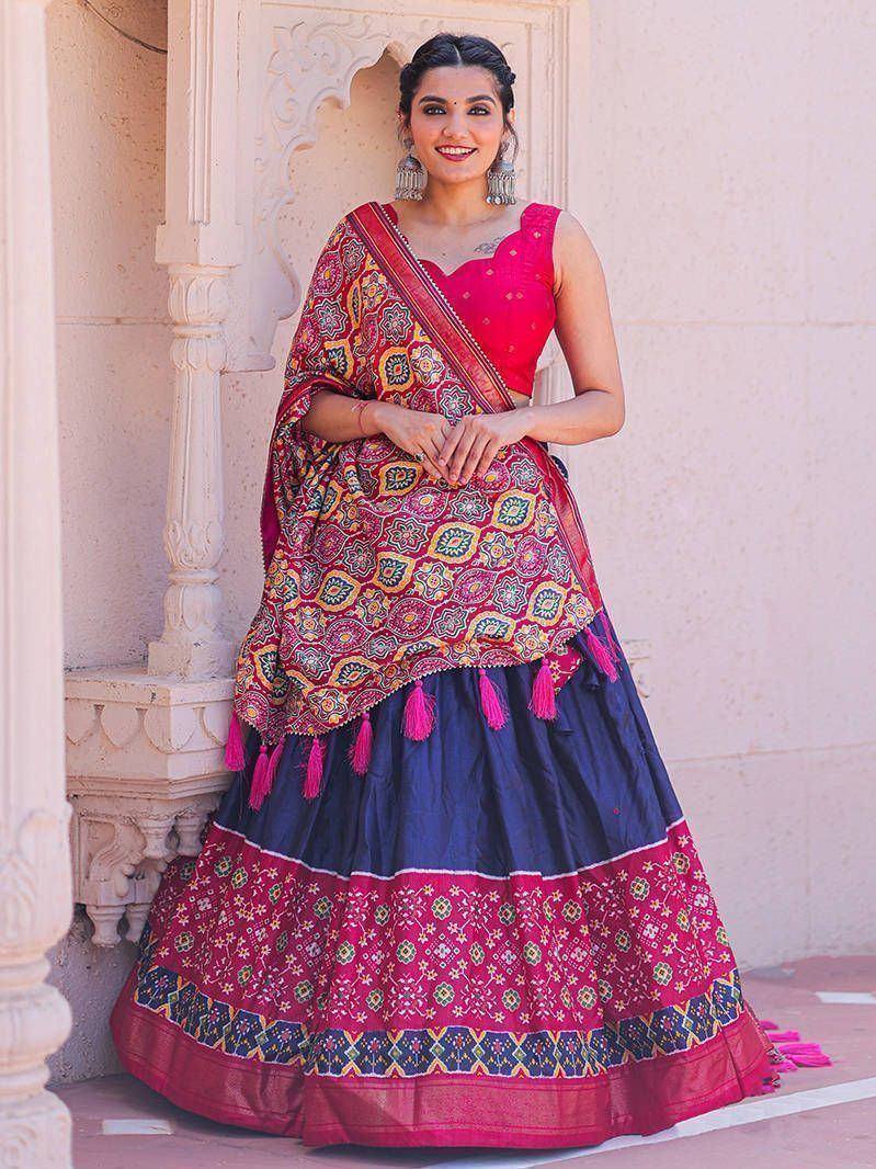 Woman in vibrant pink and navy blue lehenga choli with floral print and tassels, perfect for Indian ethnic occasions