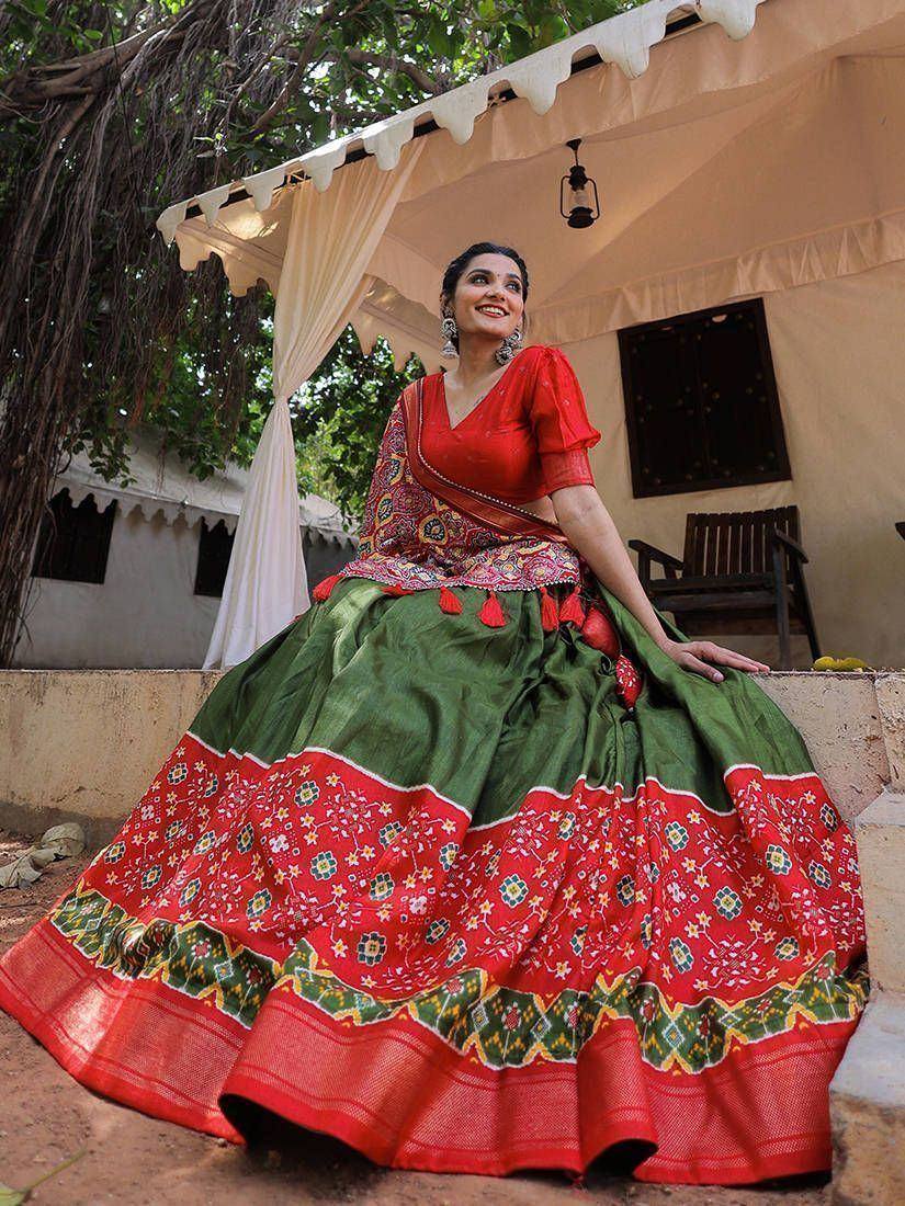 Woman in vibrant red and green ethnic lehenga choli with floral embroidery, perfect for festive occasions