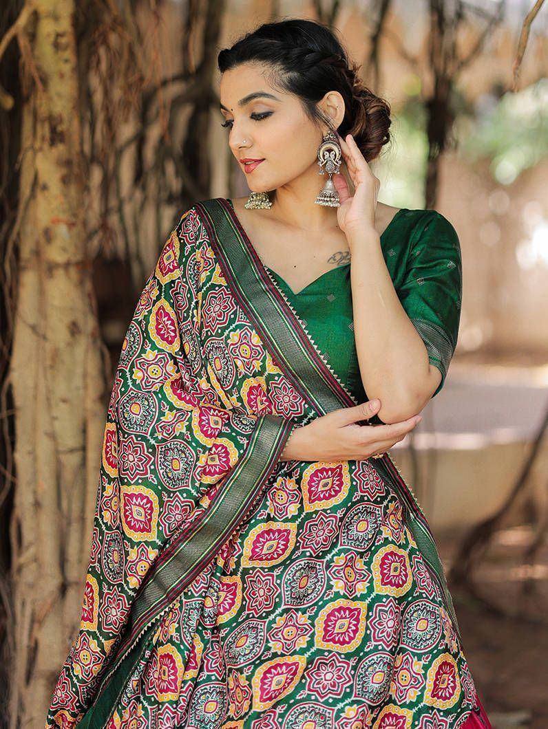 Woman in vibrant green printed saree with floral motifs, styled with jhumka earrings, perfect for ethnic occasions
