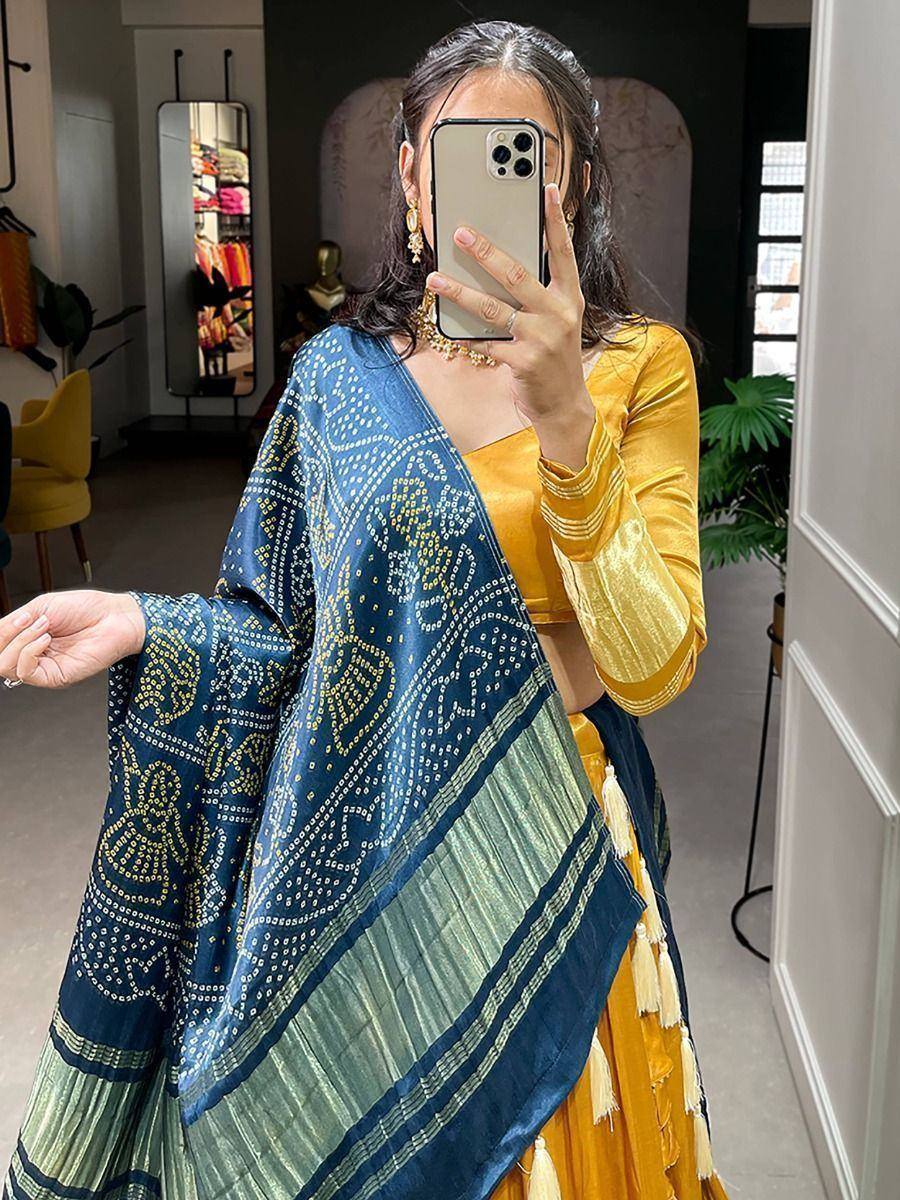 Woman in yellow velvet lehenga choli with blue printed dupatta, ethnic Indian wear