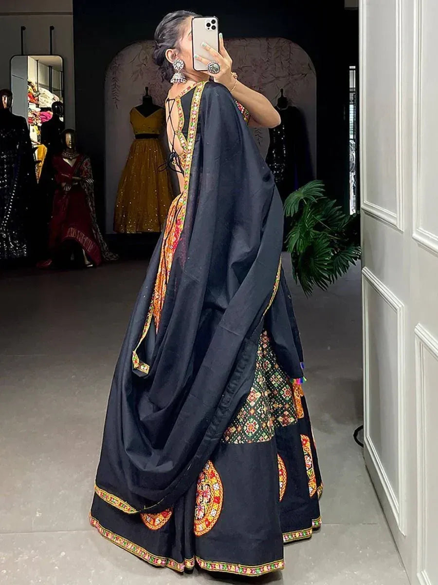Black embroidered lehenga choli with colorful floral motifs, mirror work, and dupatta, styled for ethnic occasions