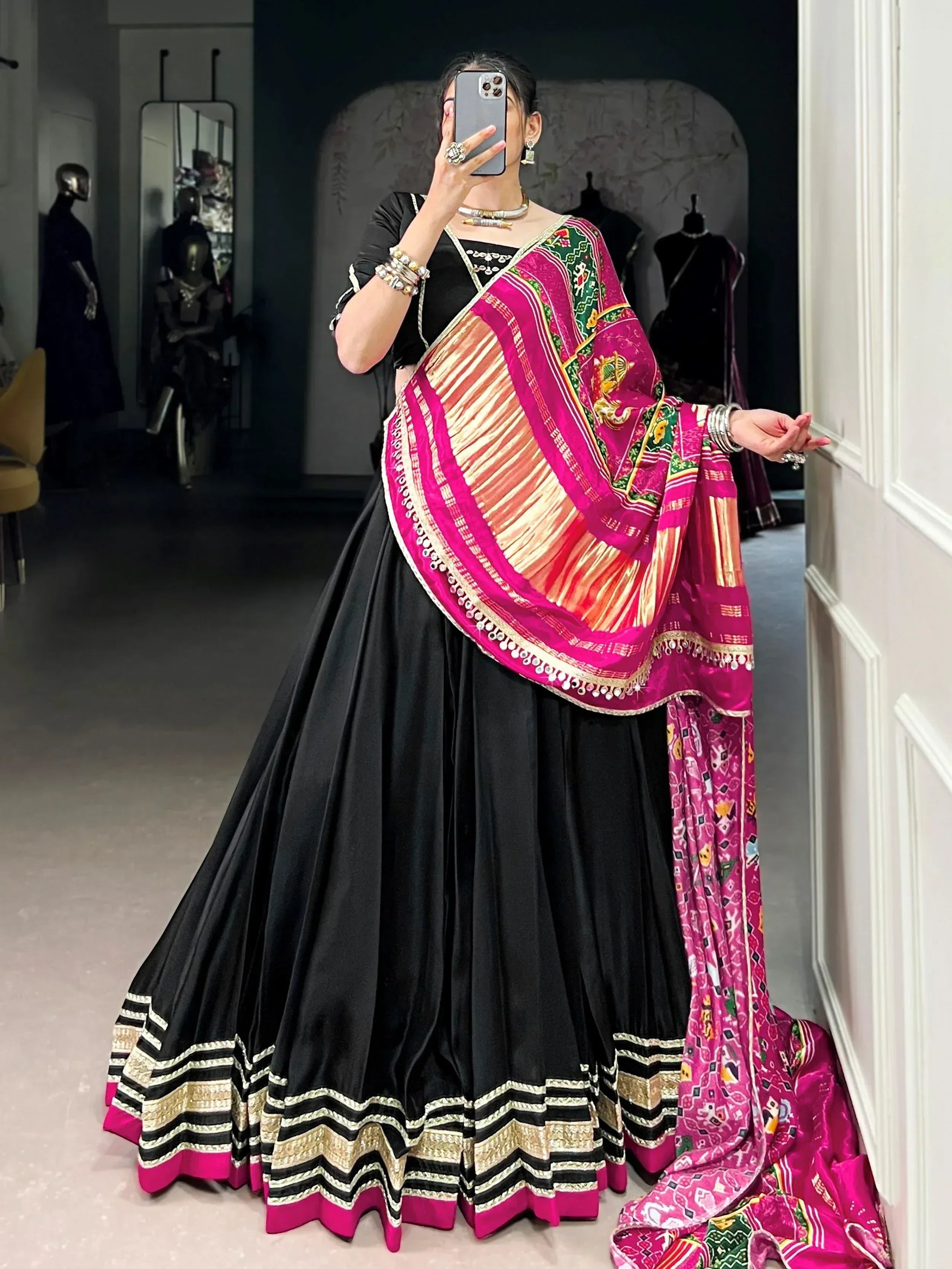 Black lehenga choli with vibrant pink embroidered dupatta, ethnic Indian wear for festive occasions