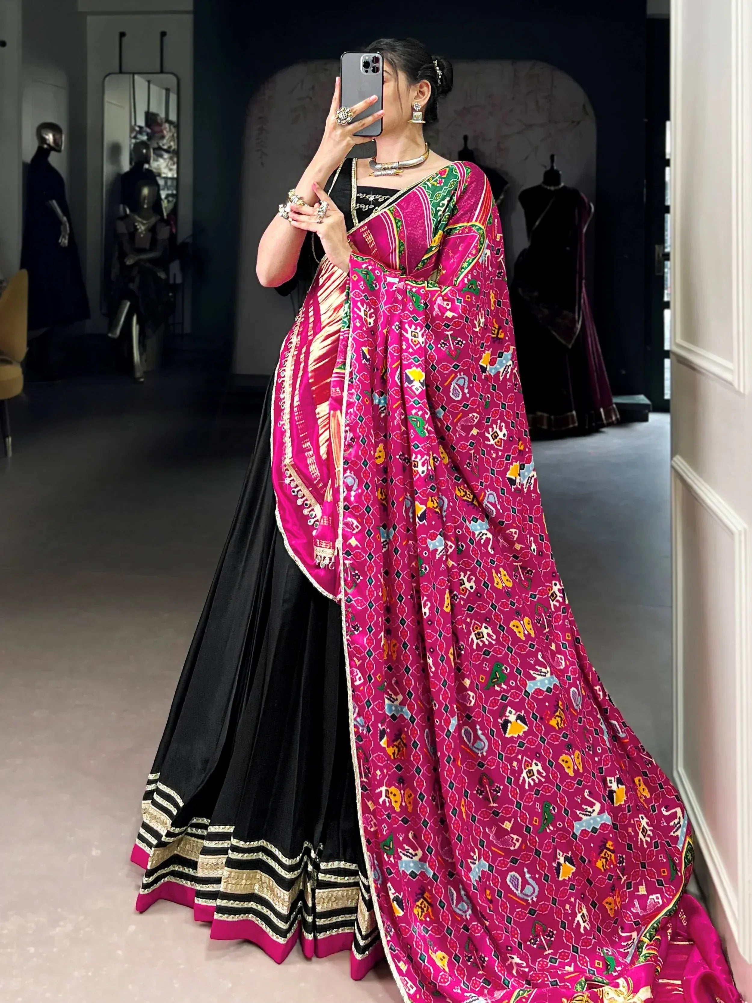 Woman in black lehenga with vibrant pink printed dupatta, ethnic Indian wear