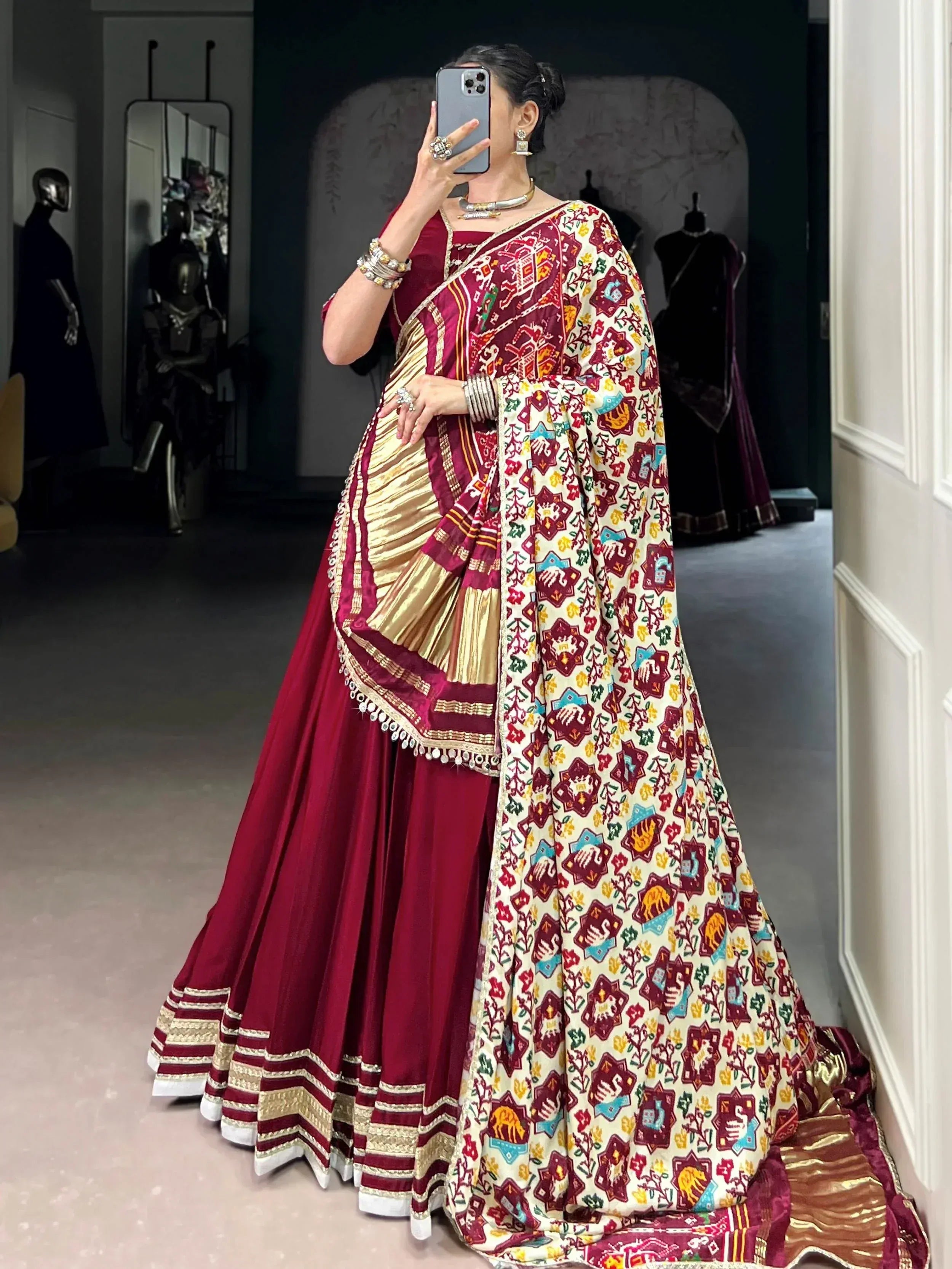 Woman in maroon designer lehenga choli with colorful printed dupatta, ethnic Indian wear