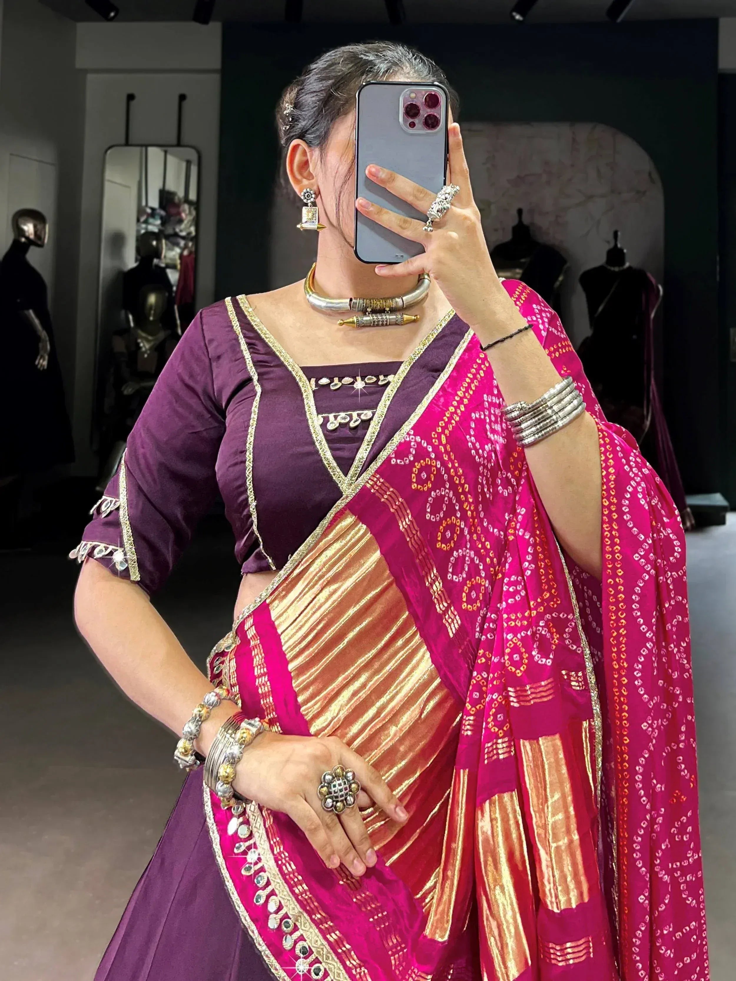 Woman in purple blouse and pink patterned saree with gold border, traditional Indian ethnic wear