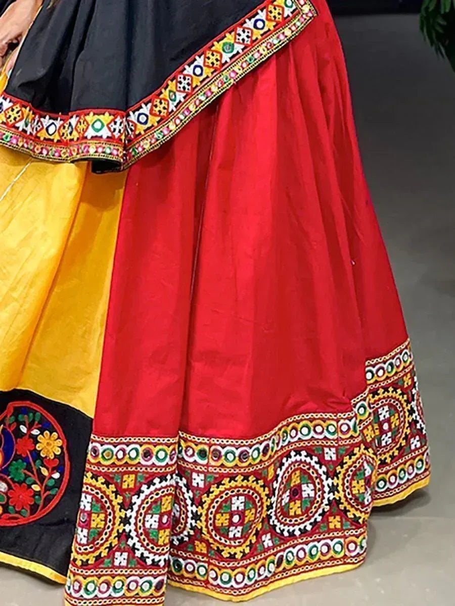 Vibrant red and yellow ethnic lehenga with intricate mirror and thread embroidery, perfect for Indian festivals.