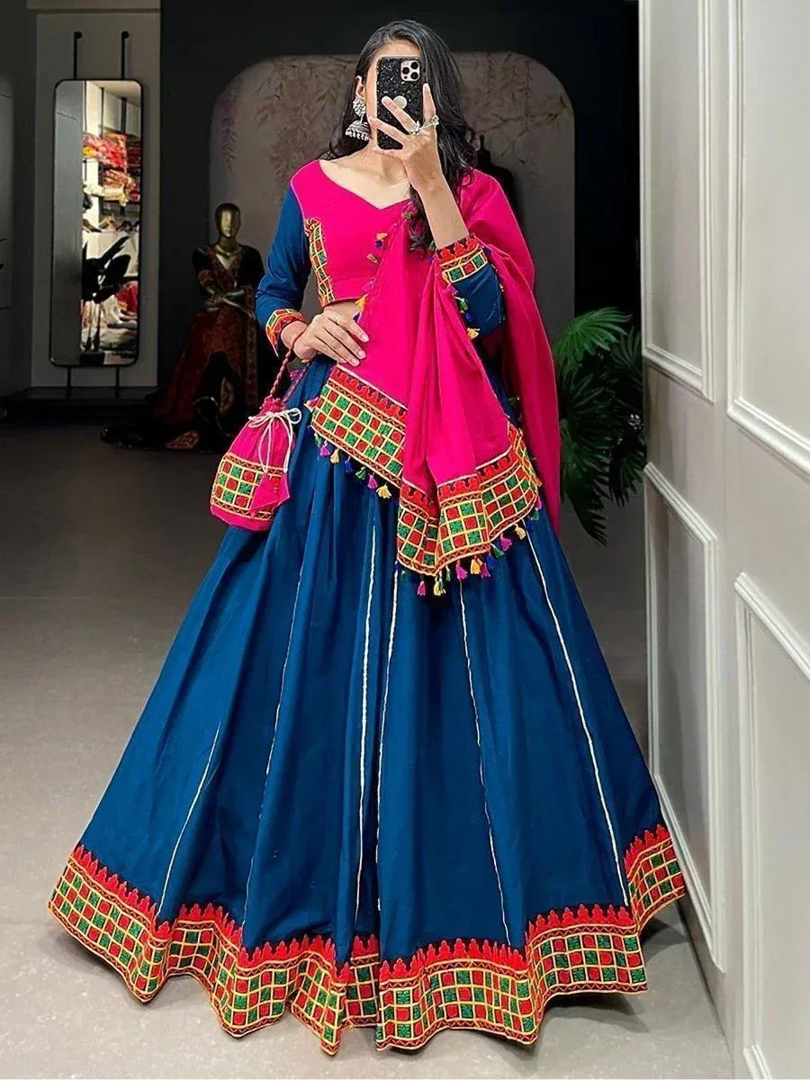 Blue and pink designer lehenga choli with embroidered dupatta and matching potli bag, perfect for Indian ethnic occasions.