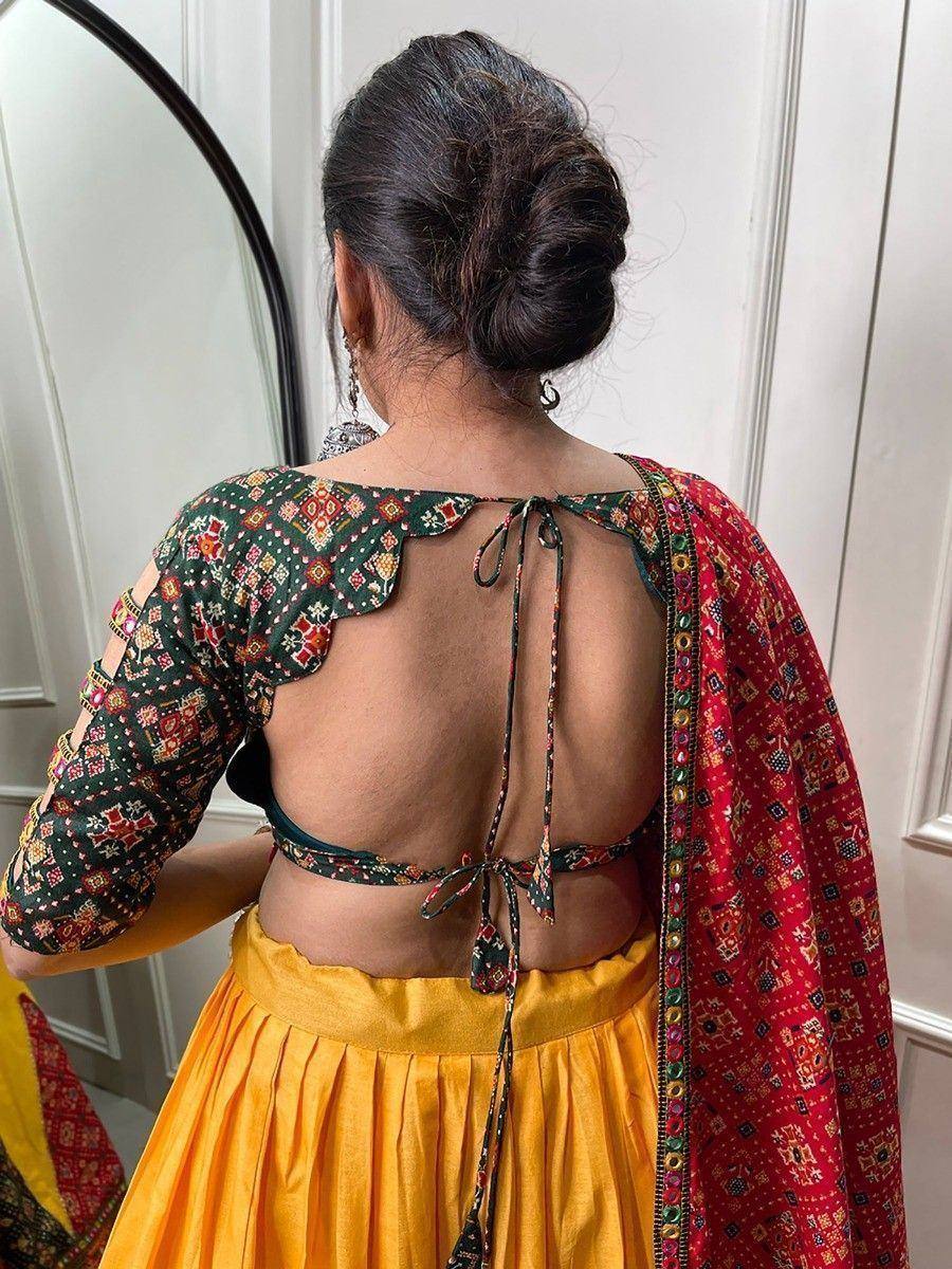 Back view of woman in colorful ethnic lehenga choli with open back and tie-up detail, paired with red dupatta