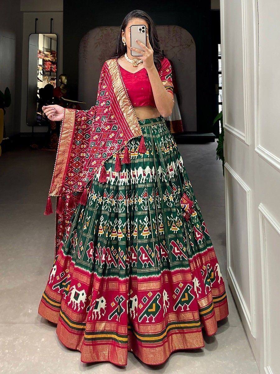 Vibrant green and red printed lehenga choli with ethnic motifs and tassels, perfect for festive occasions.