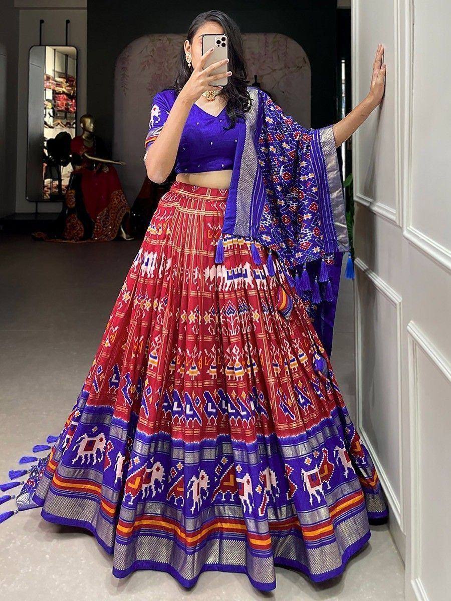 Vibrant red and blue printed lehenga choli with ethnic motifs and tassels, perfect for festive occasions