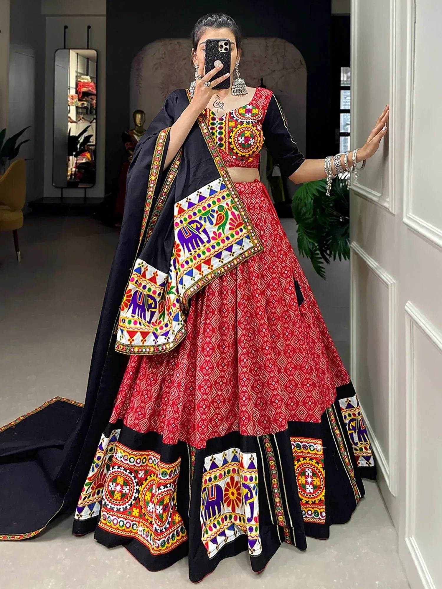 Vibrant red and black embroidered lehenga choli with mirror work and elephant motifs, perfect for Indian ethnic wear.