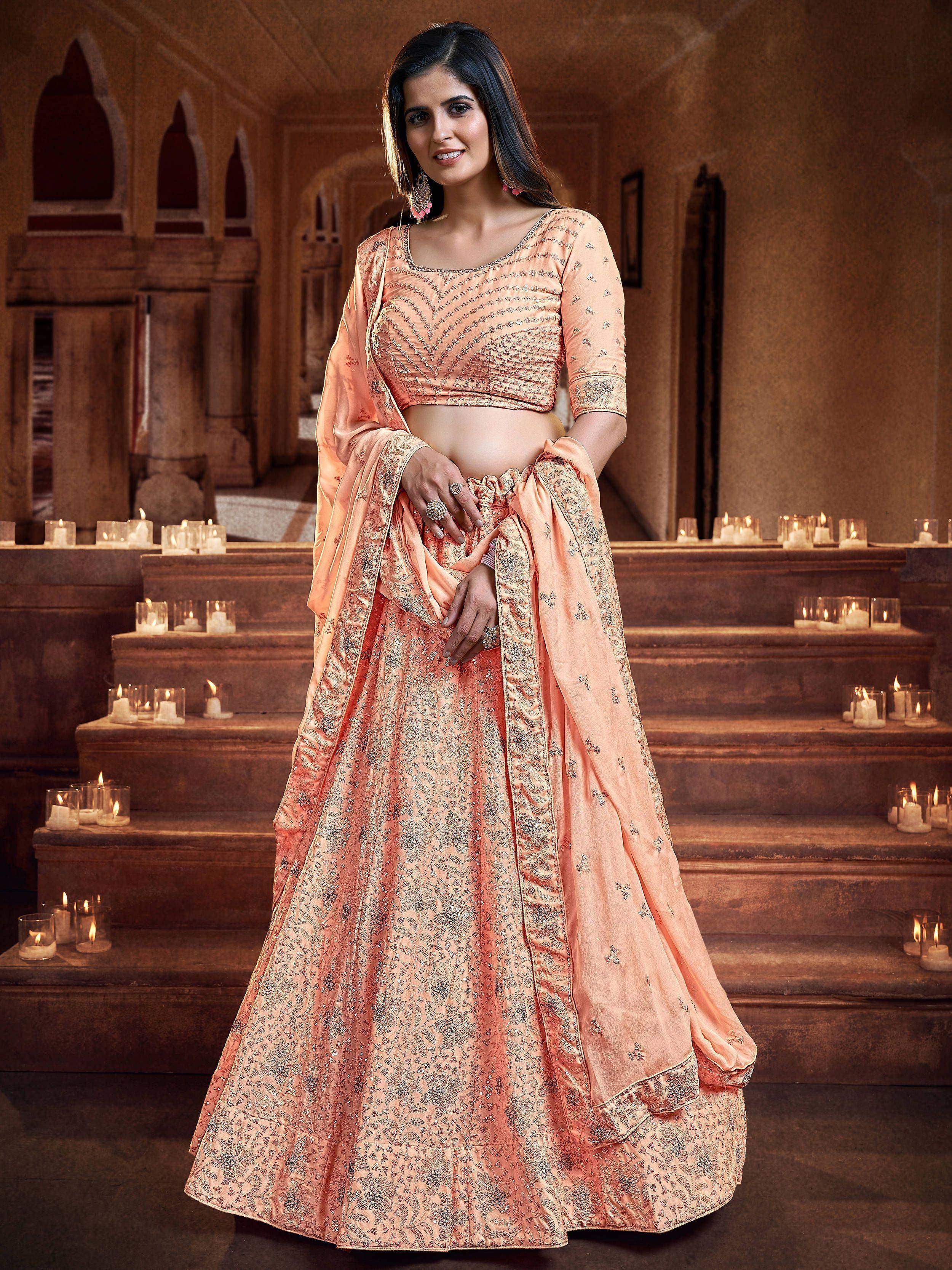Peach designer lehenga choli with intricate embroidery, perfect for Indian weddings and festive occasions.