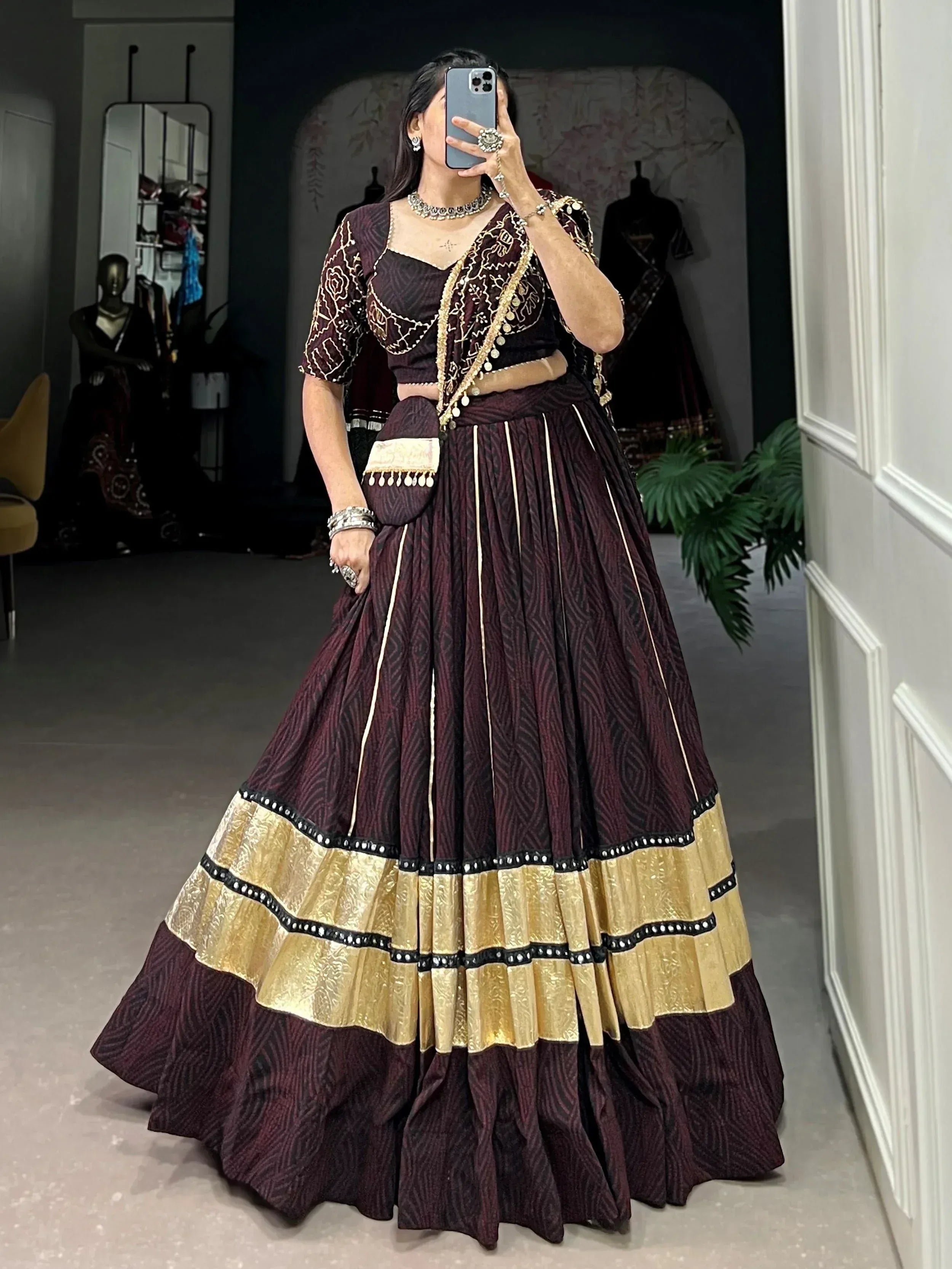 Maroon and gold designer lehenga choli with intricate embroidery and pleated skirt, perfect for Indian ethnic wear occasions.