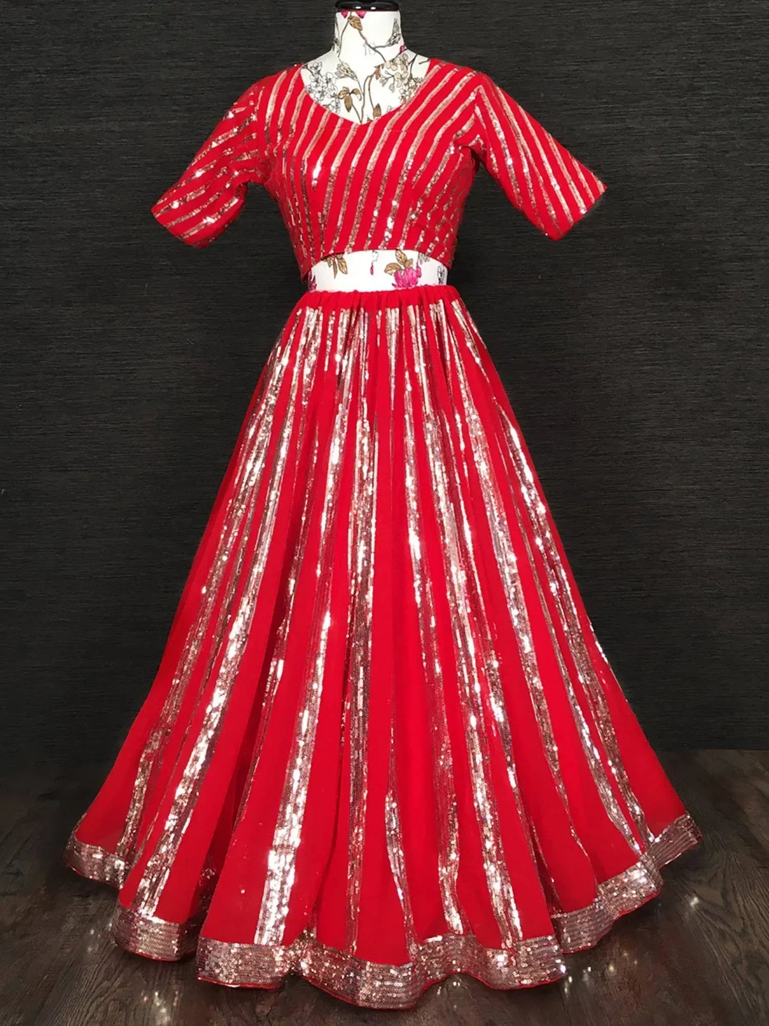 Red sequin striped ethnic gown with floral waistband, perfect for Indian celebrations and festive occasions.