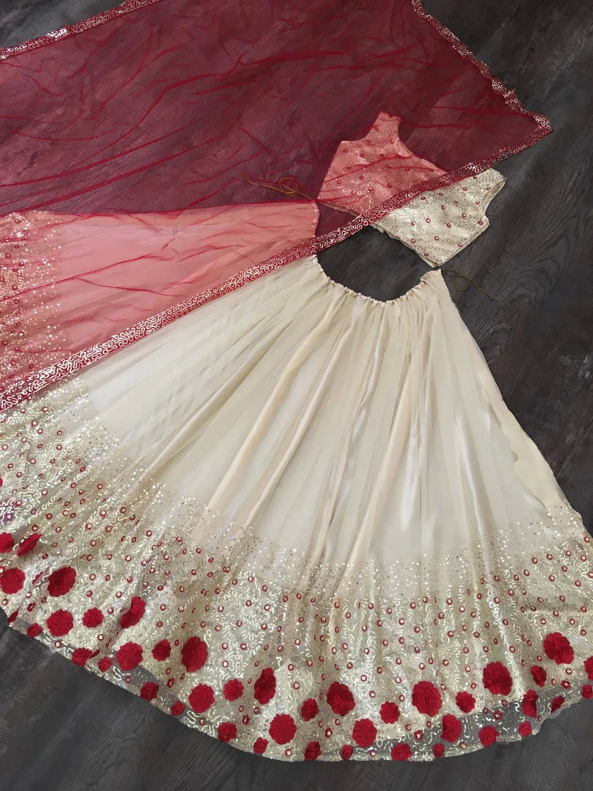 Cream and red designer lehenga choli with floral embroidery and sequin work, perfect for Indian ethnic wear.