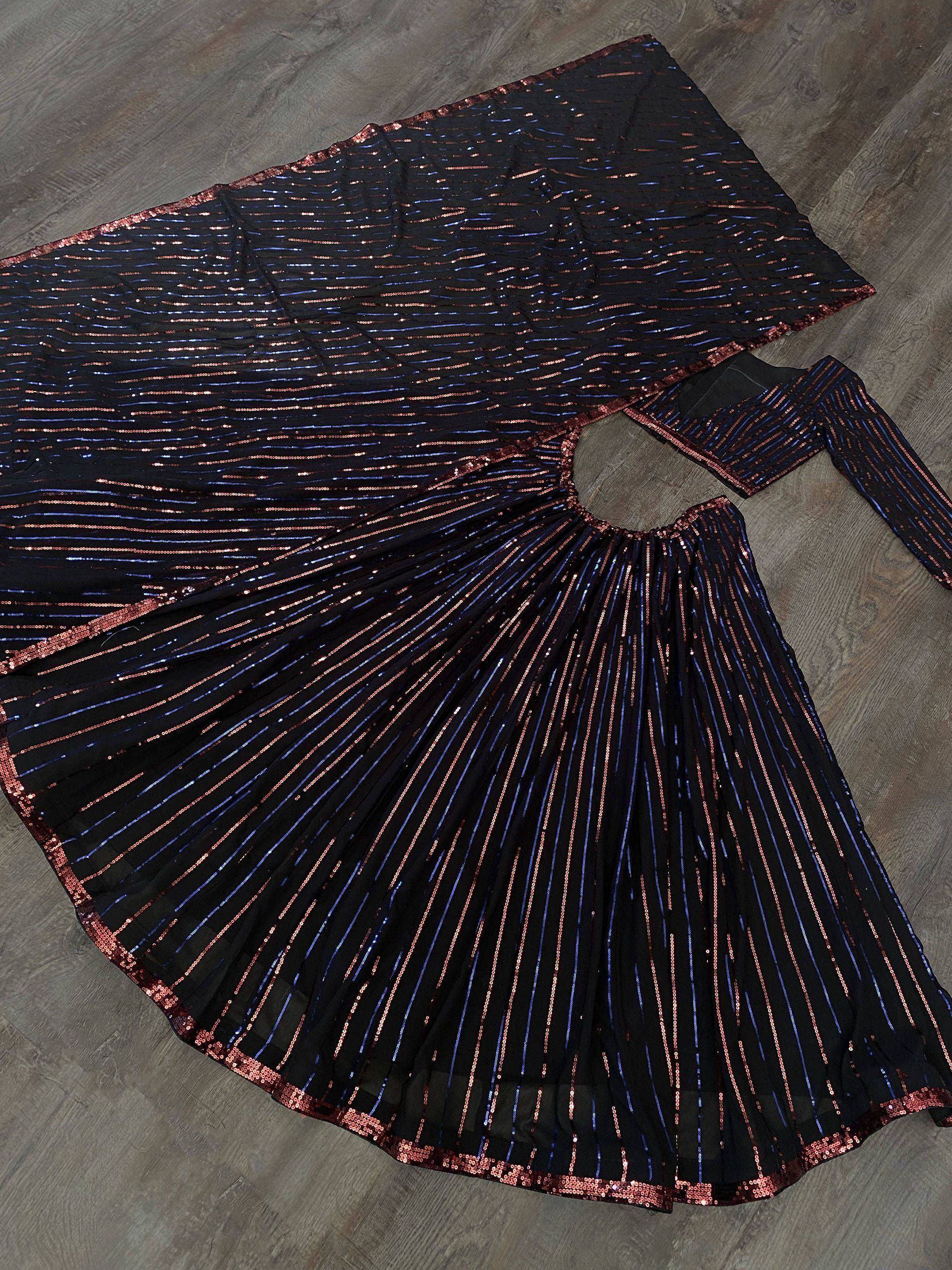 Black sequin ethnic gown with blue and copper stripes, pleated skirt, laid on wood floor