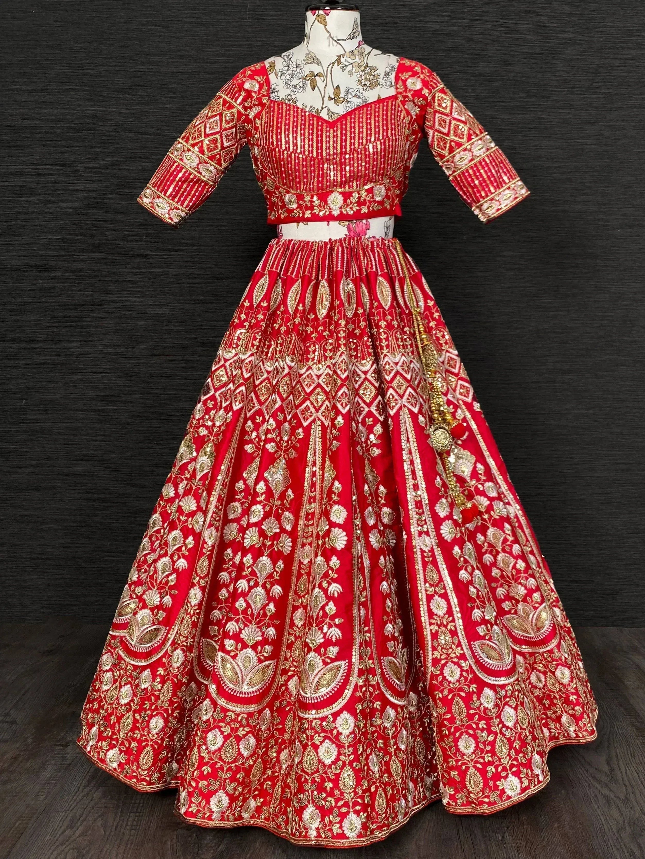 Red designer lehenga choli with gold embroidery, perfect for Indian weddings and festive occasions.